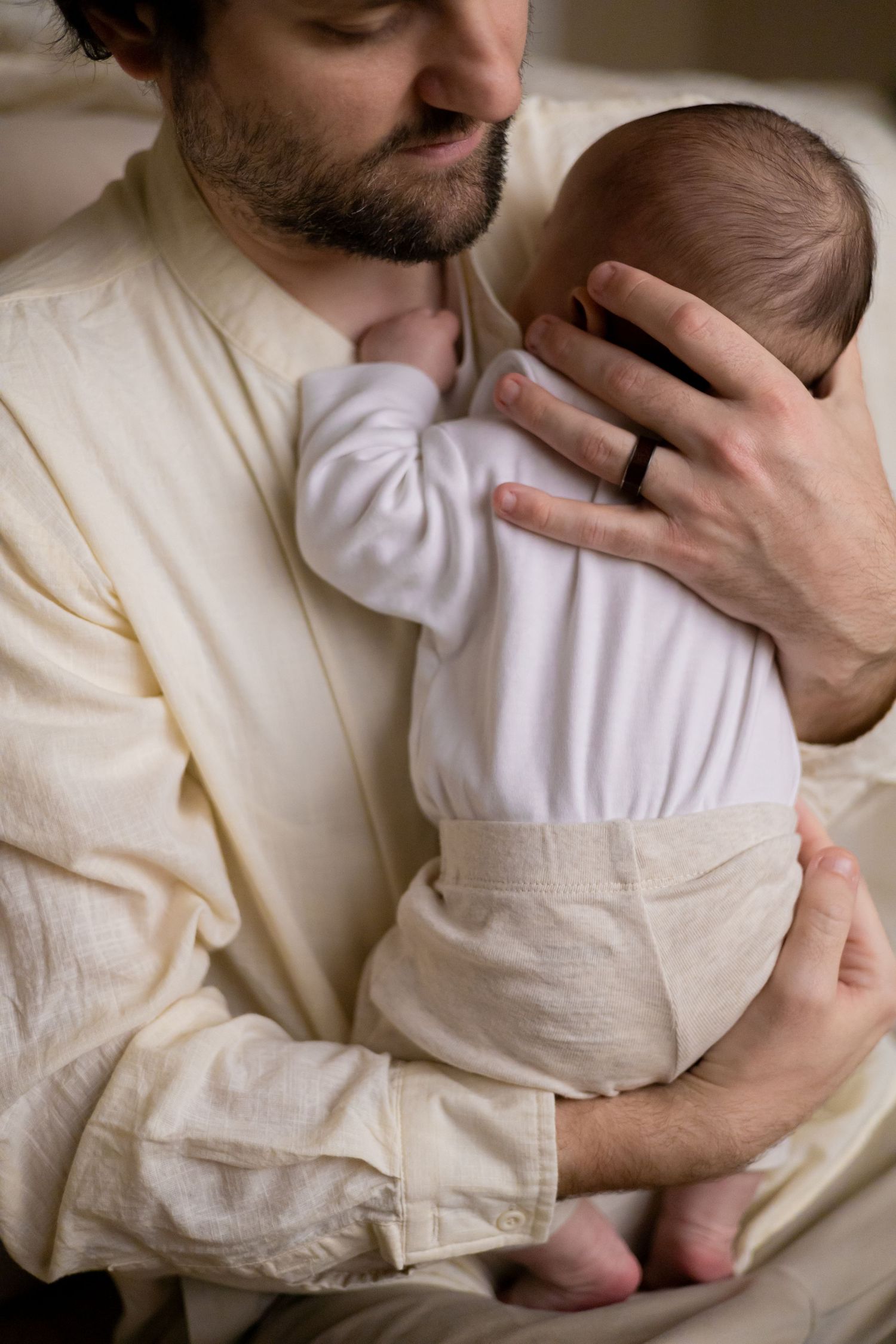 Father holding his newborn baby twins during a lifestyle newborn session
