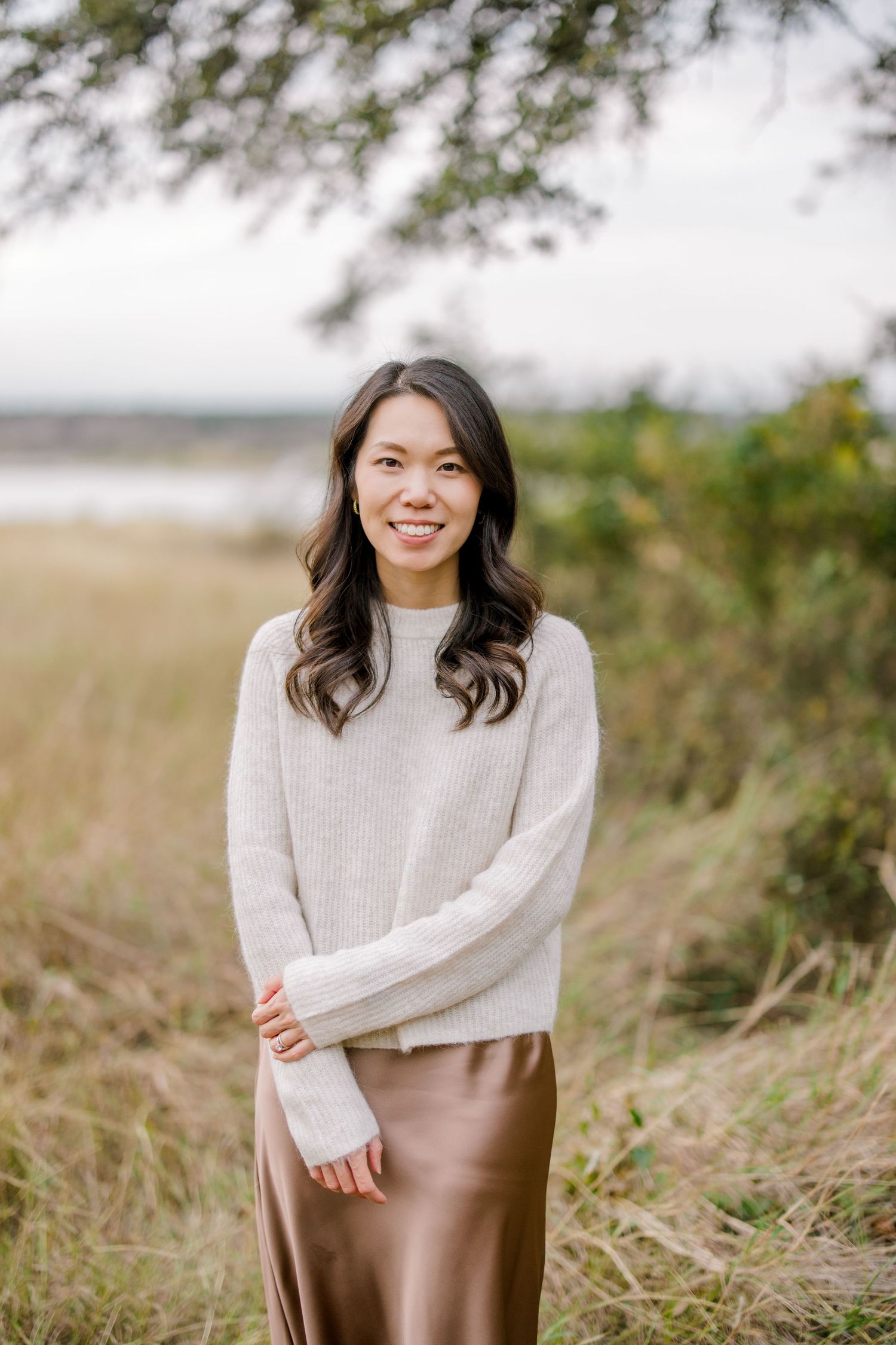 Photographer smiling at the camera in an outdoor park near a lake