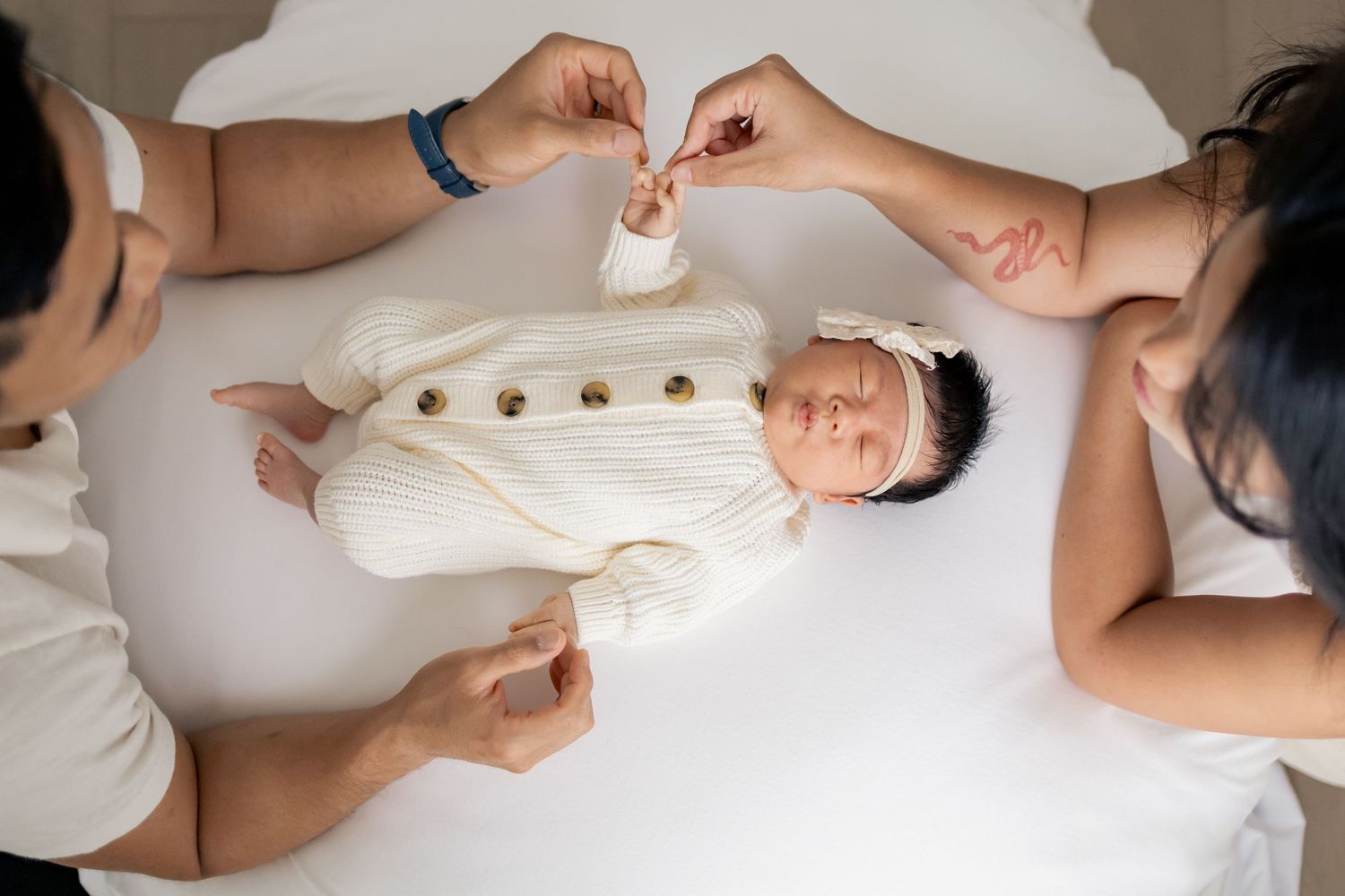Parents playing with newborn baby during a natural light lifestyle newborn session