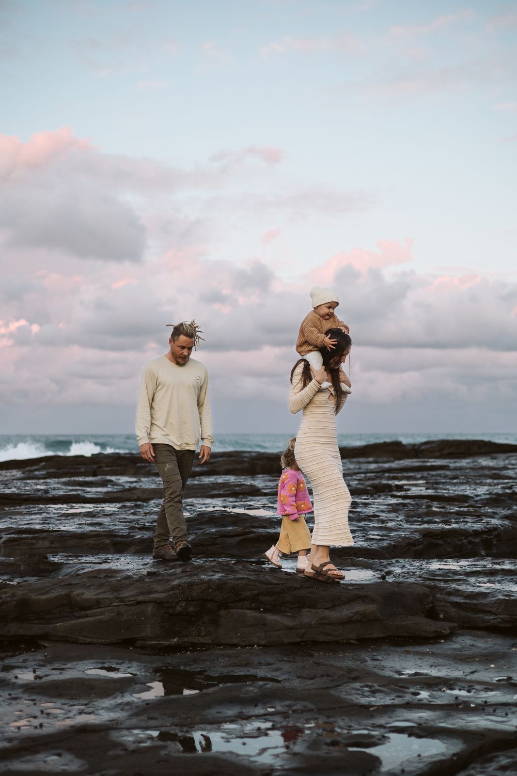 Family of four, winter coastal photoshoot with stunning sunset.