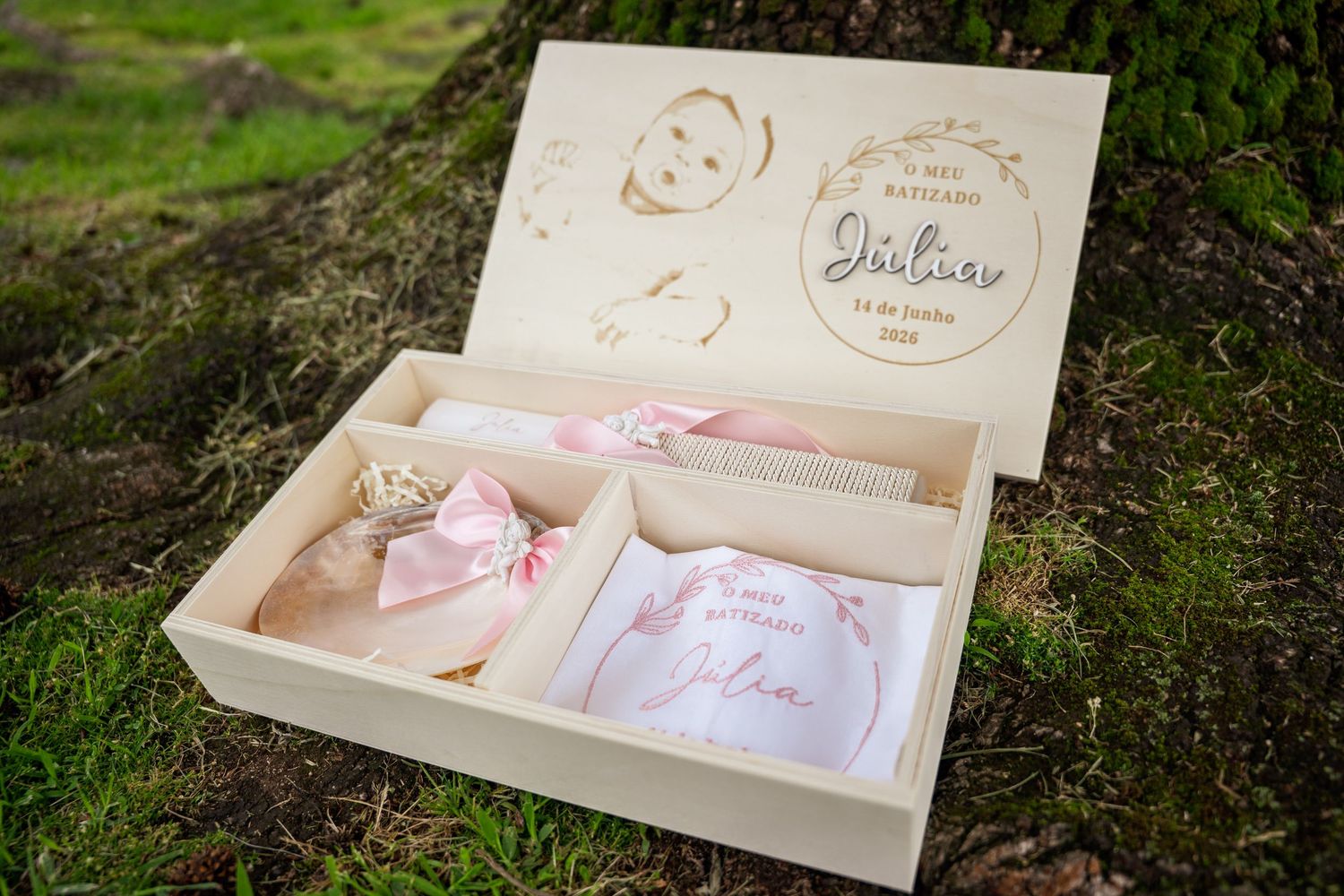 Personalized wooden baby keepsake box with engraved name Julius, containing pink ribbon gifts and embroidered cloth.