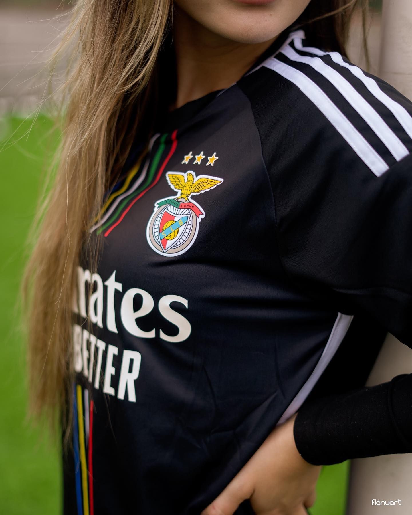 Close-up of woman wearing black Benfica Adidas football jersey outdoors.