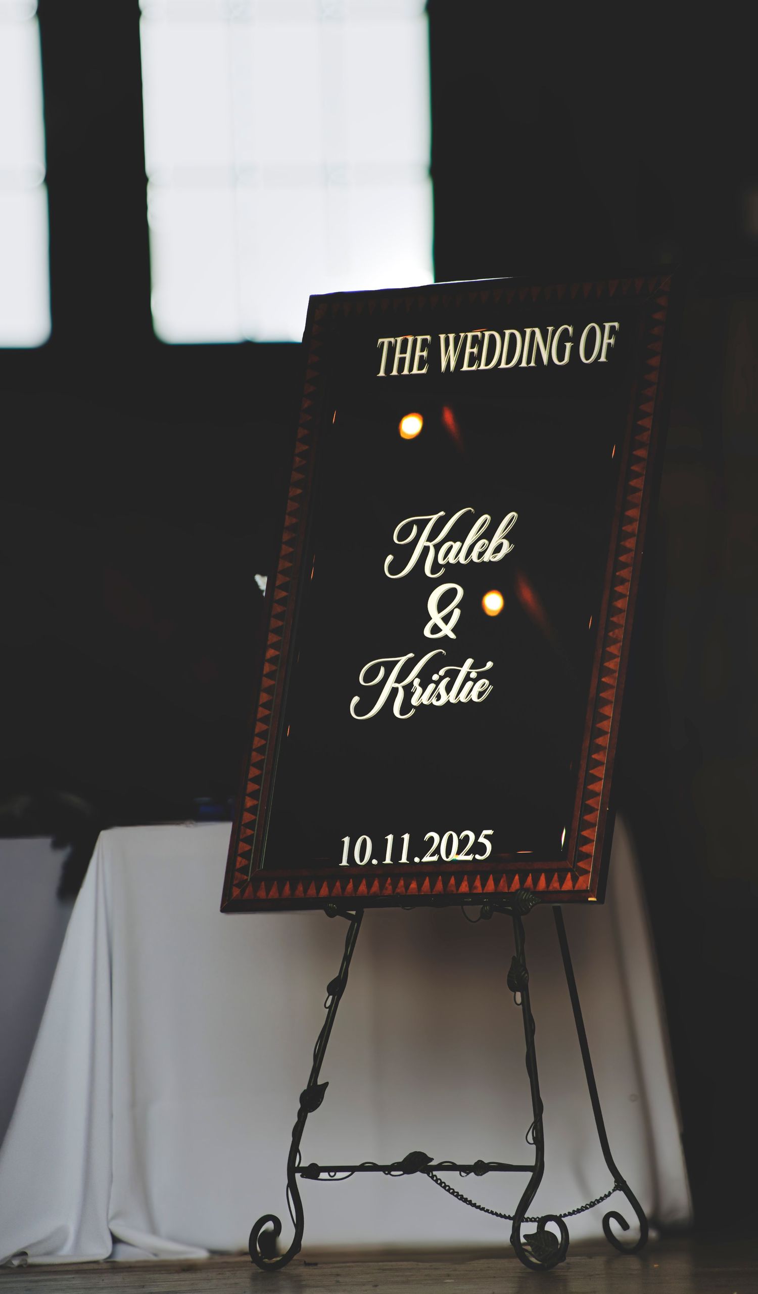 Elegant black wedding welcome sign for Kaleb and Kristie on an ornate easel, dated 10.11.2025.