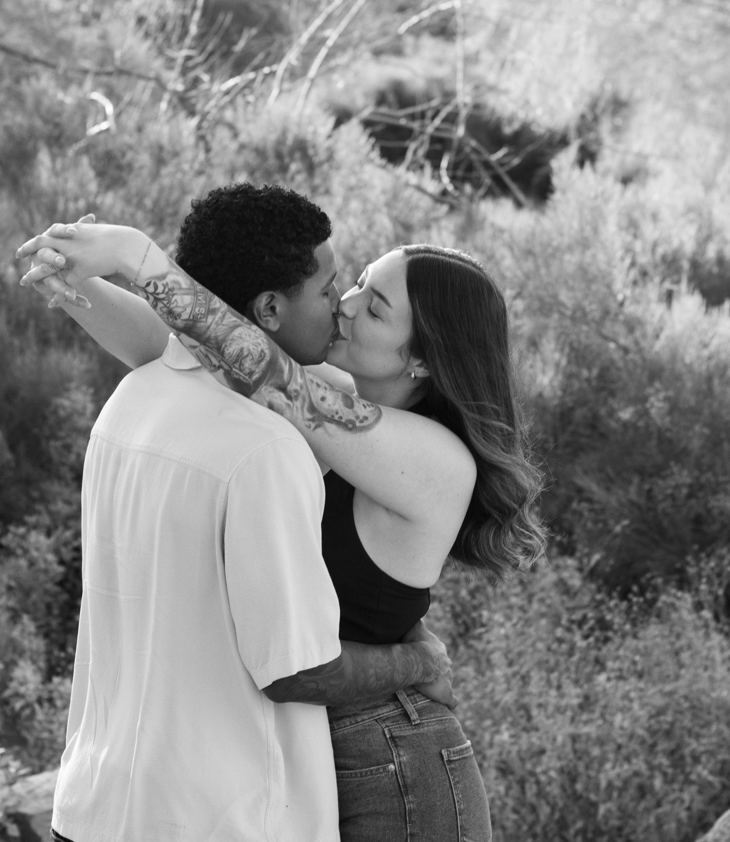 beautiful couple photoshoot and pose is lady laying on boyfriends shoulder and pretty arizona background . casual photoshoot
black and white