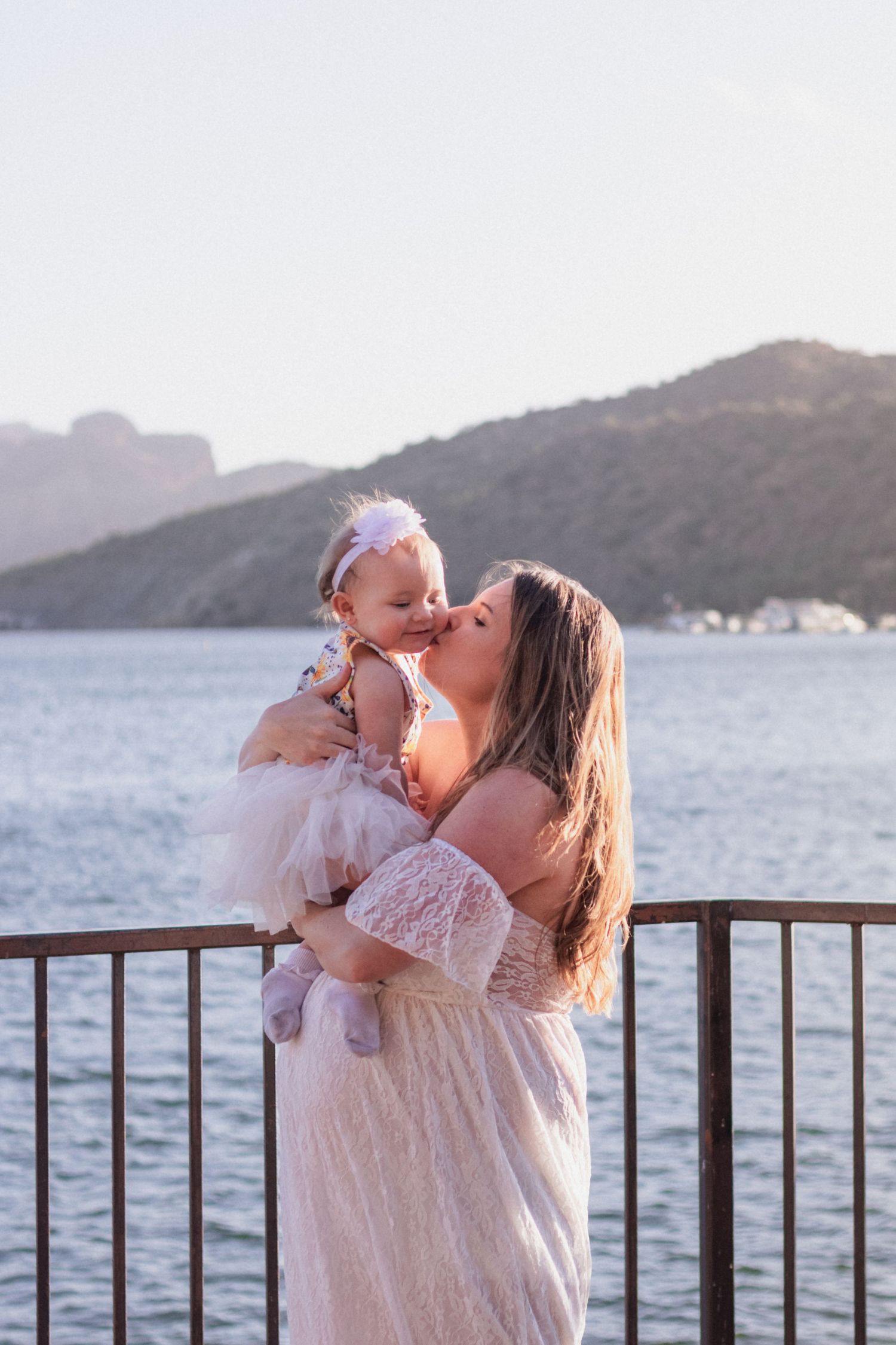 pregnancy maternity shoot. Arizona photoshoot with lake and sunset. white crown and white dress with baby