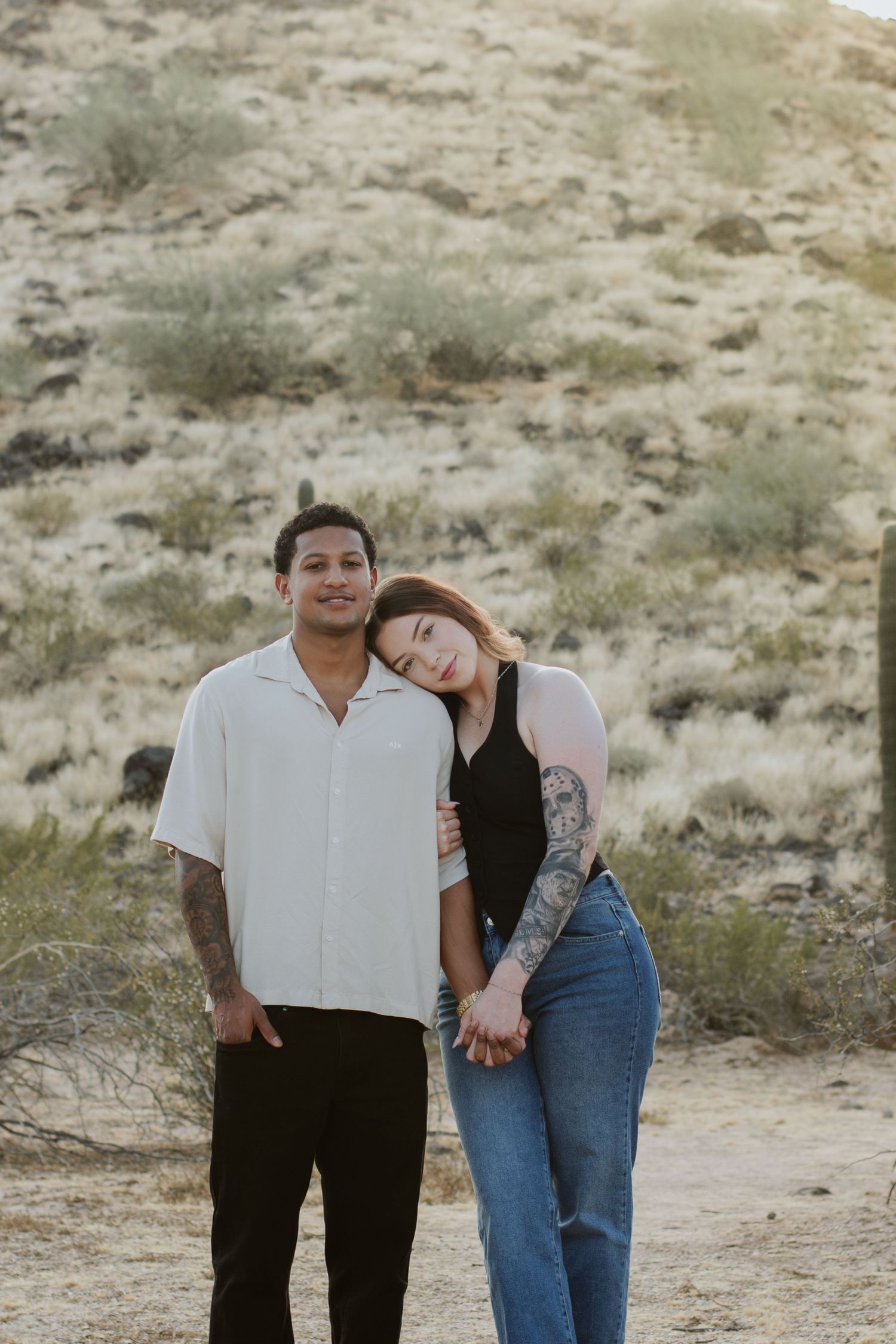 beautiful couple photoshoot and pose is lady laying on boyfriends shoulder and pretty arizona background . casual photoshoot