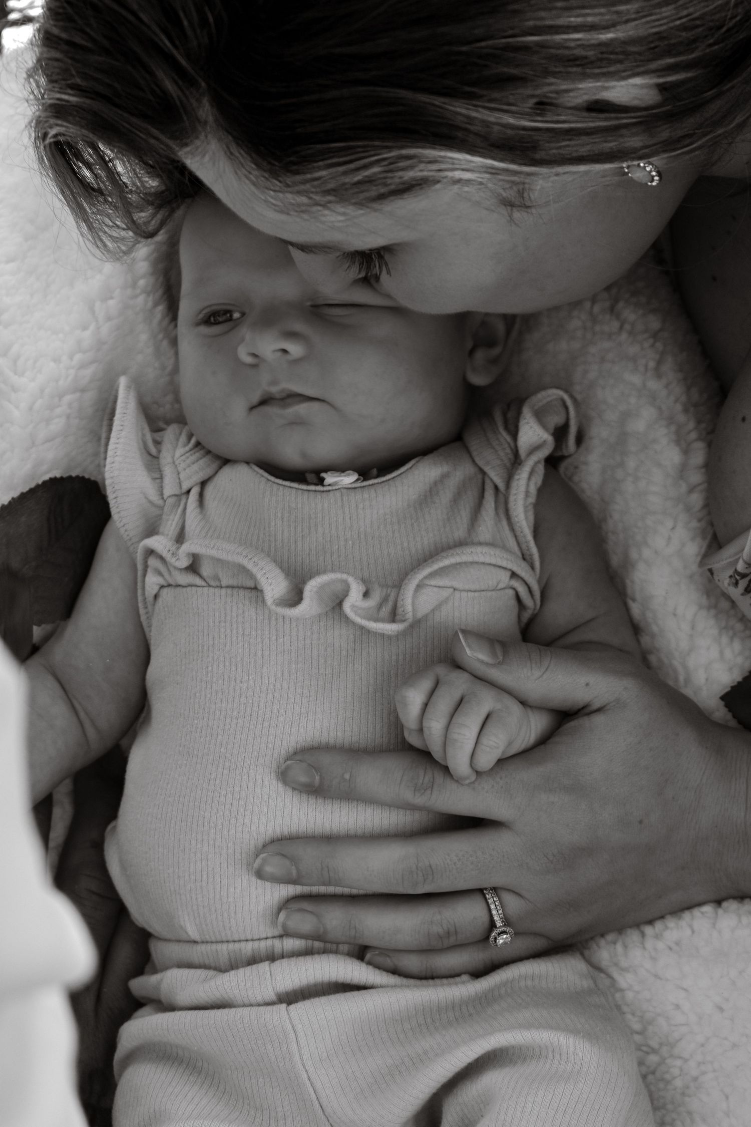 black and white detail shot of mommy kissing 3 month old baby during photoshoot