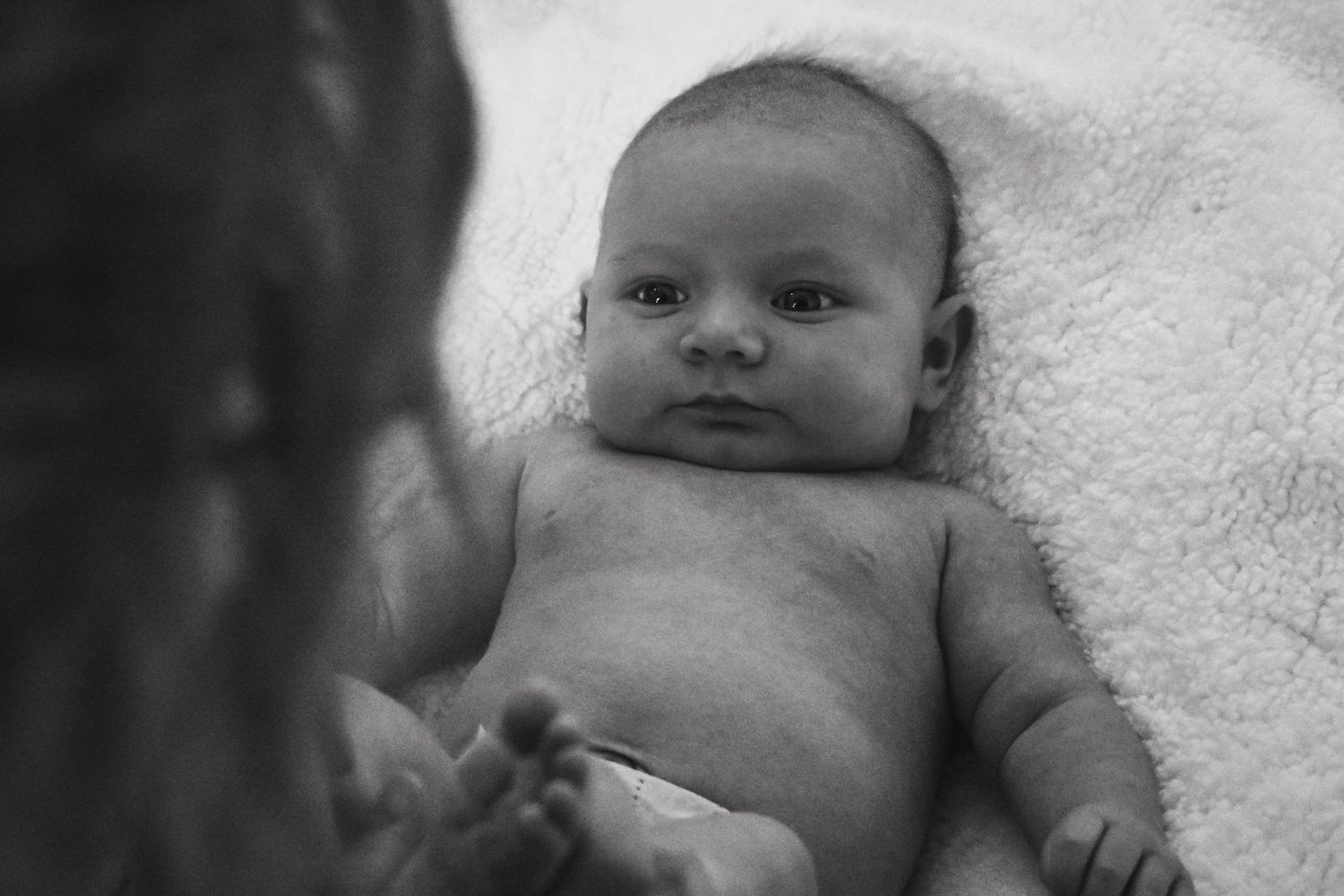 black and white dramatic photo of baby looking at grandma