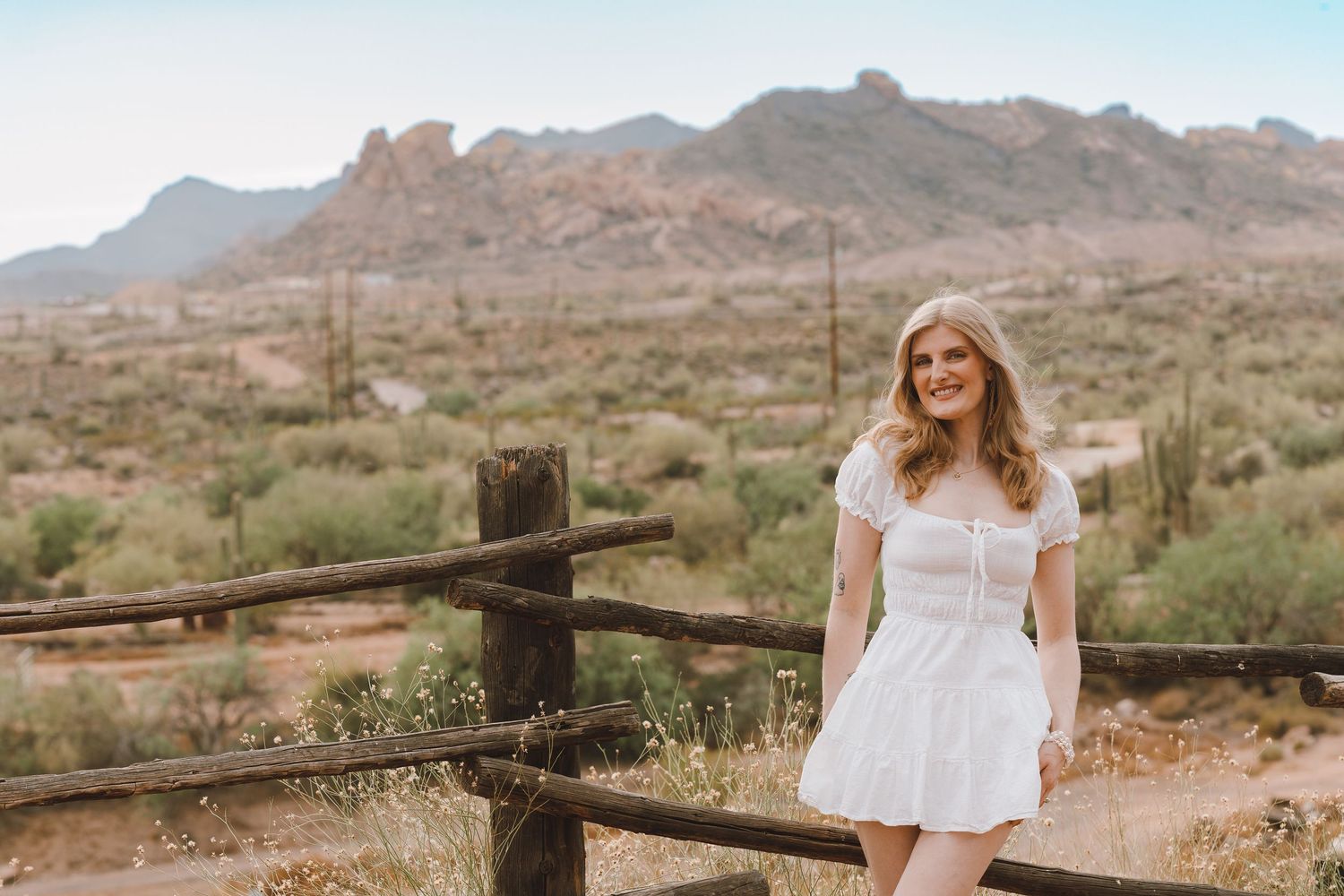 western style photoshoot with mountains and cactus in the background. mini dress and cowboy boots