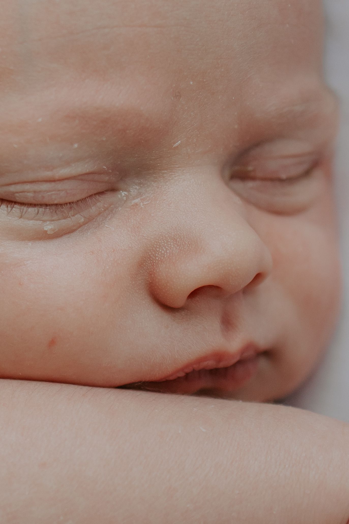 Close-up of a sleeping newborn baby with soft skin and delicate features.