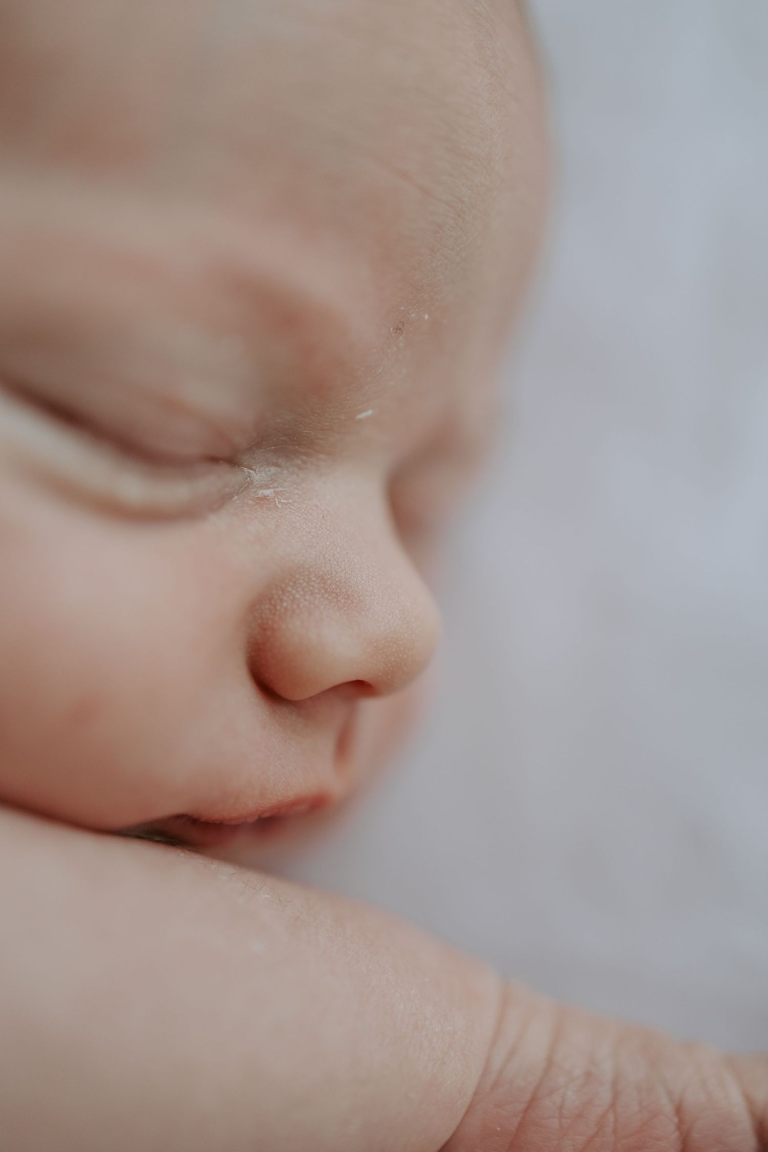 Macro close-up of peaceful sleeping newborn baby face with soft delicate skin.