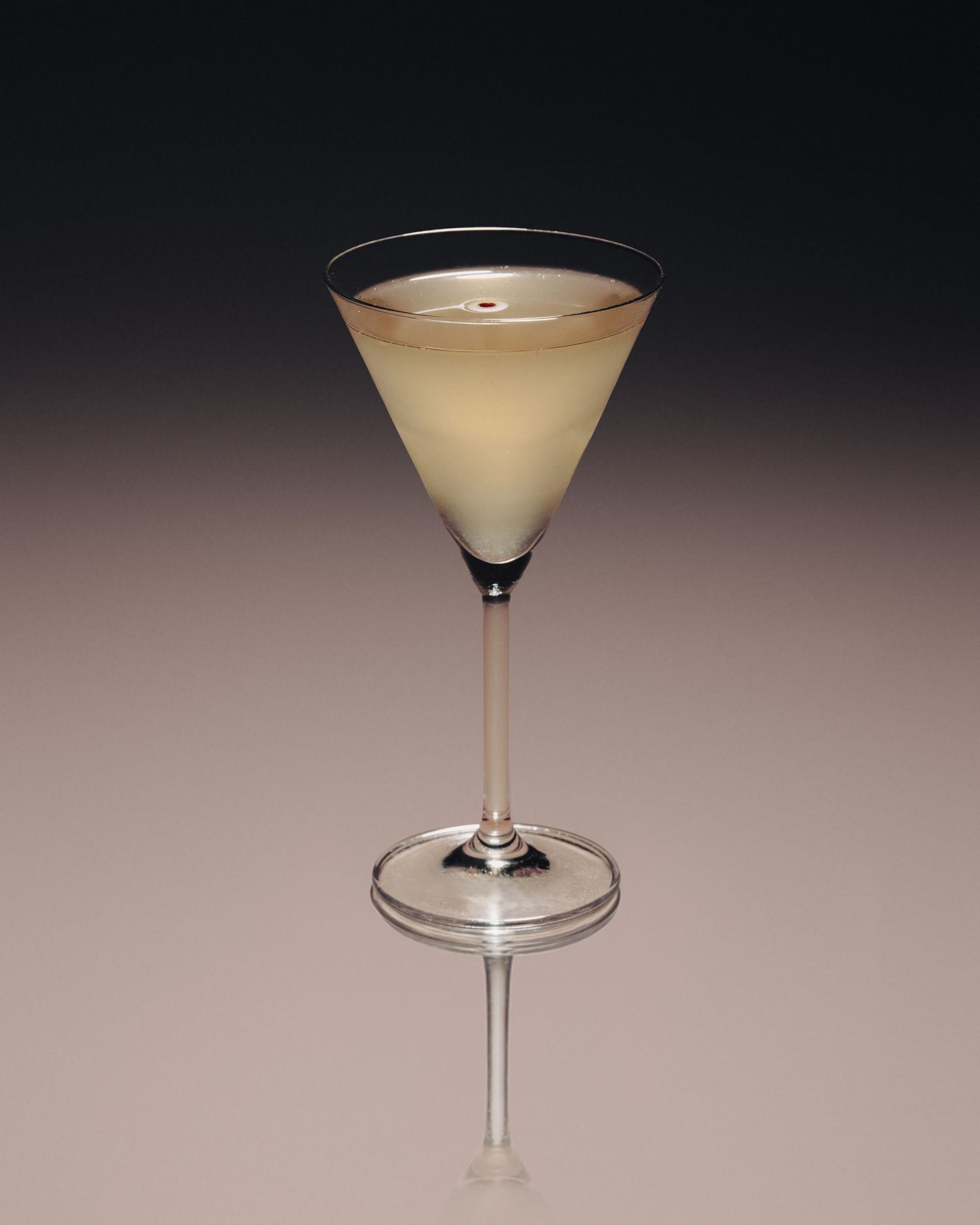 Elegant martini glass with pale yellow cocktail on gradient background, perfect for upscale bar menus.