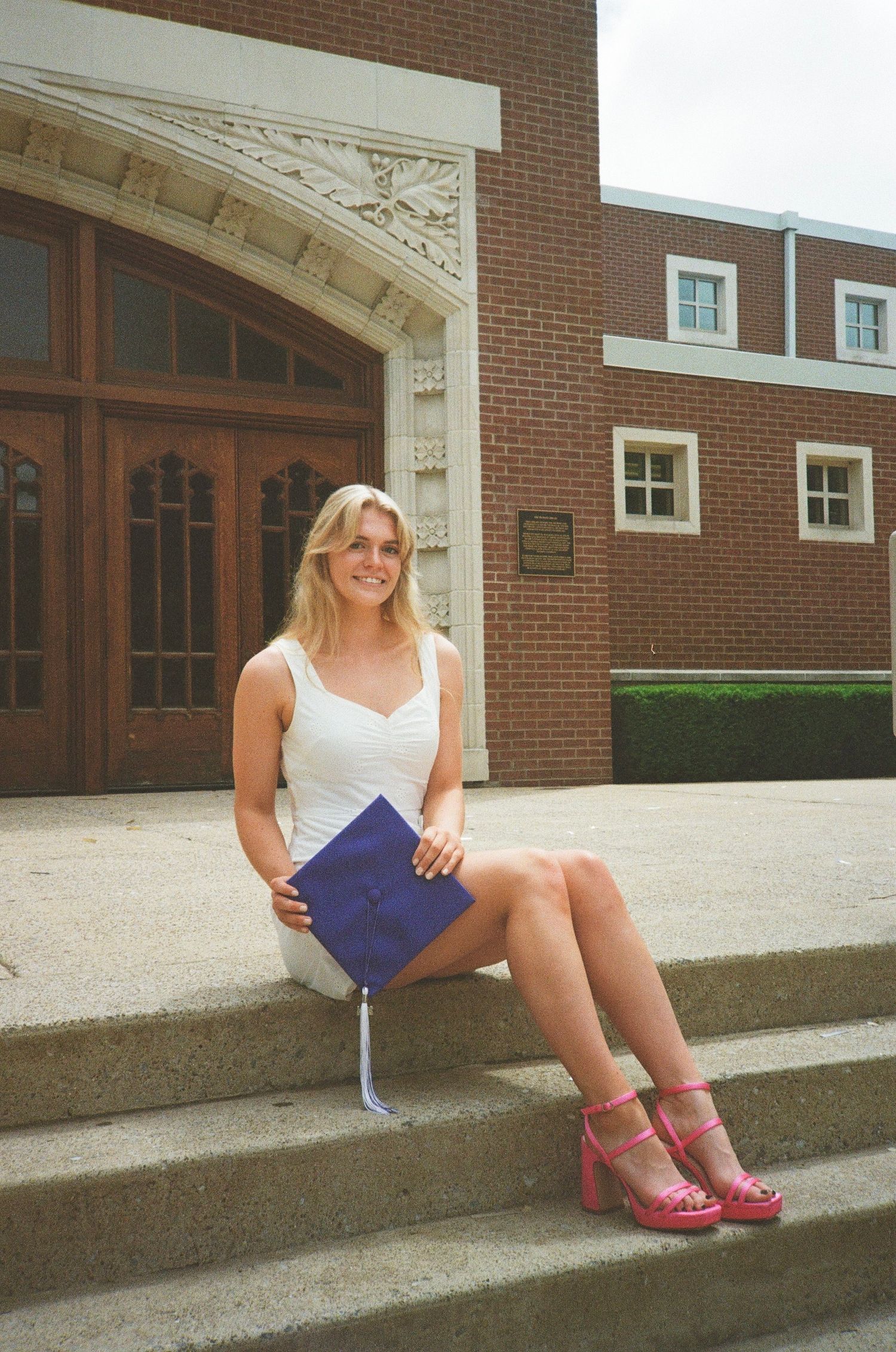 35mm photograph of a young adult (female) holding a graduation cap.