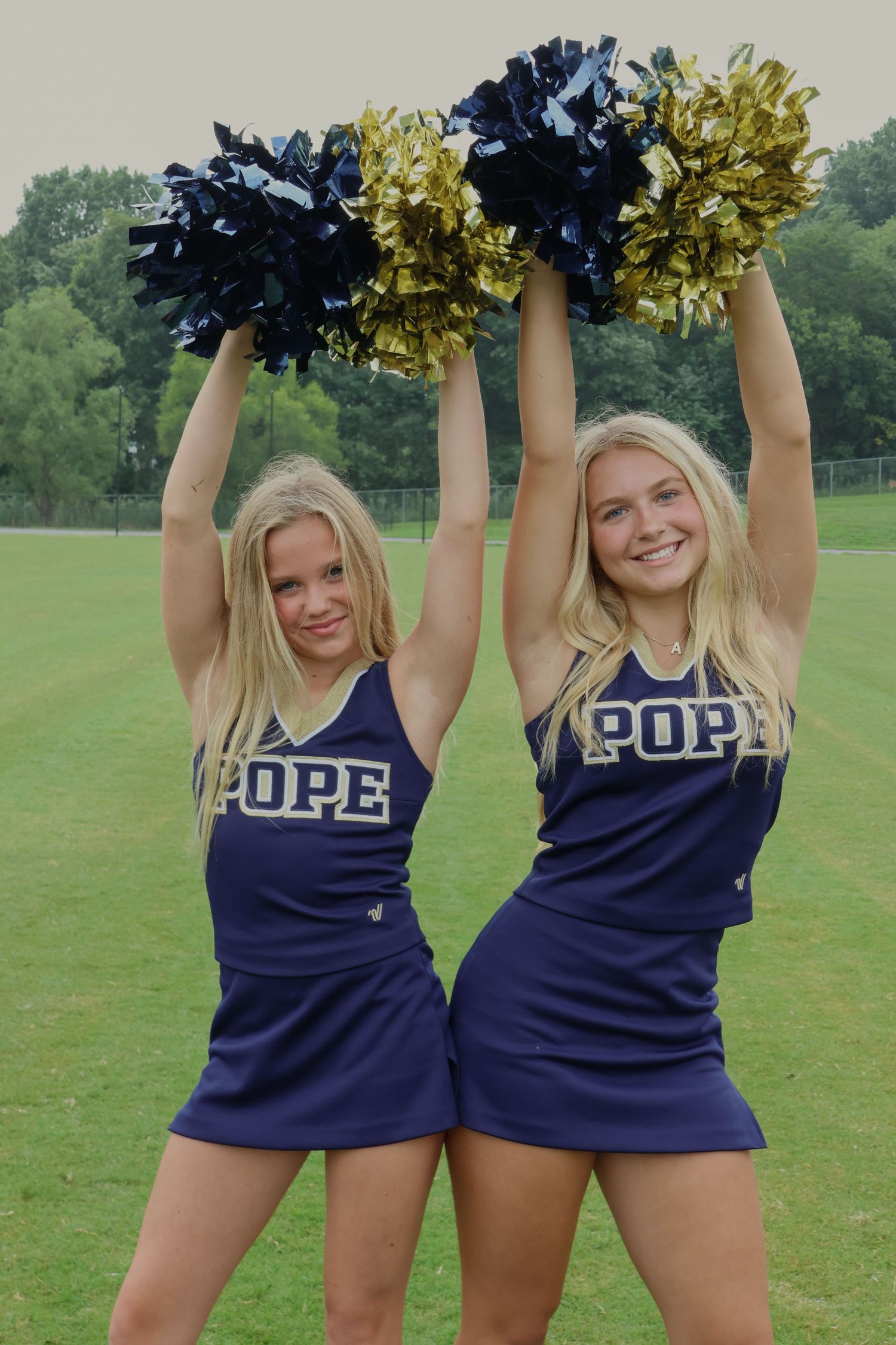 Digital photograph of 2 cheerleaders bumping hips.