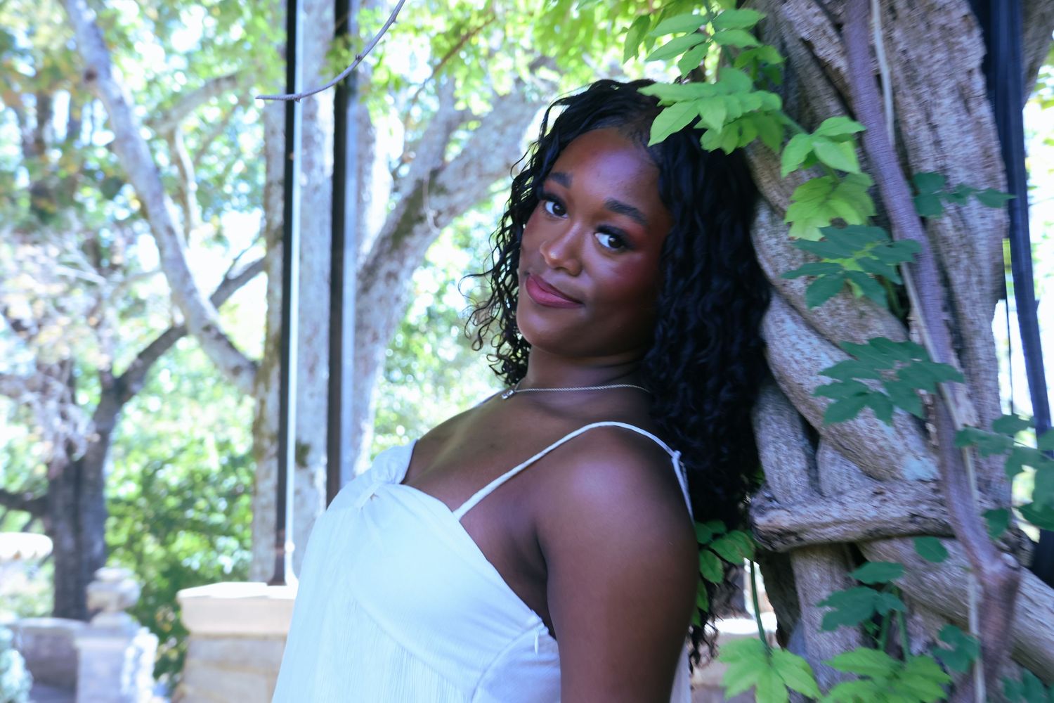 Digital photograph of a young woman against a tree.