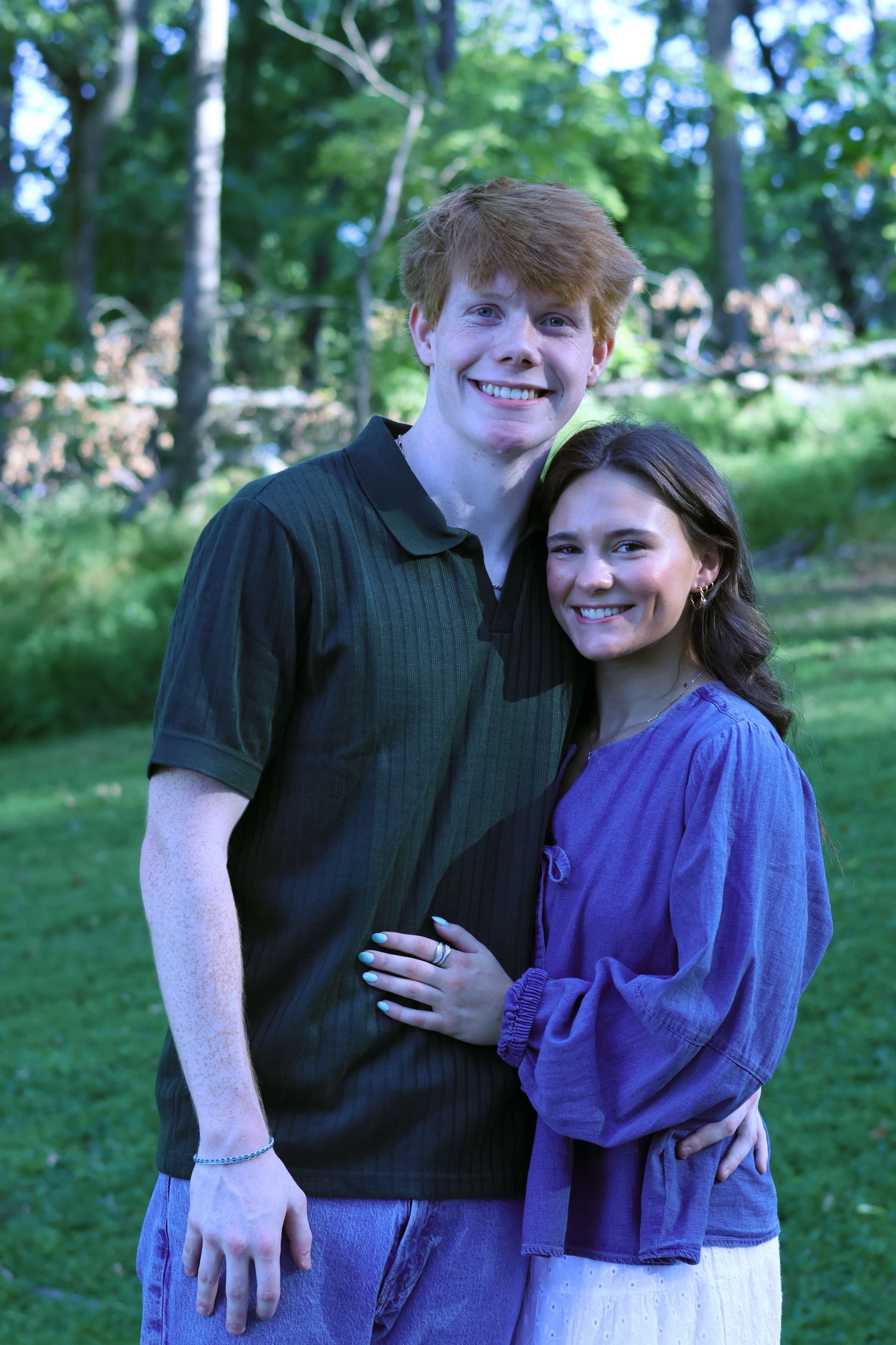 Happy couple embracing outdoors wearing coordinating casual outfits.
