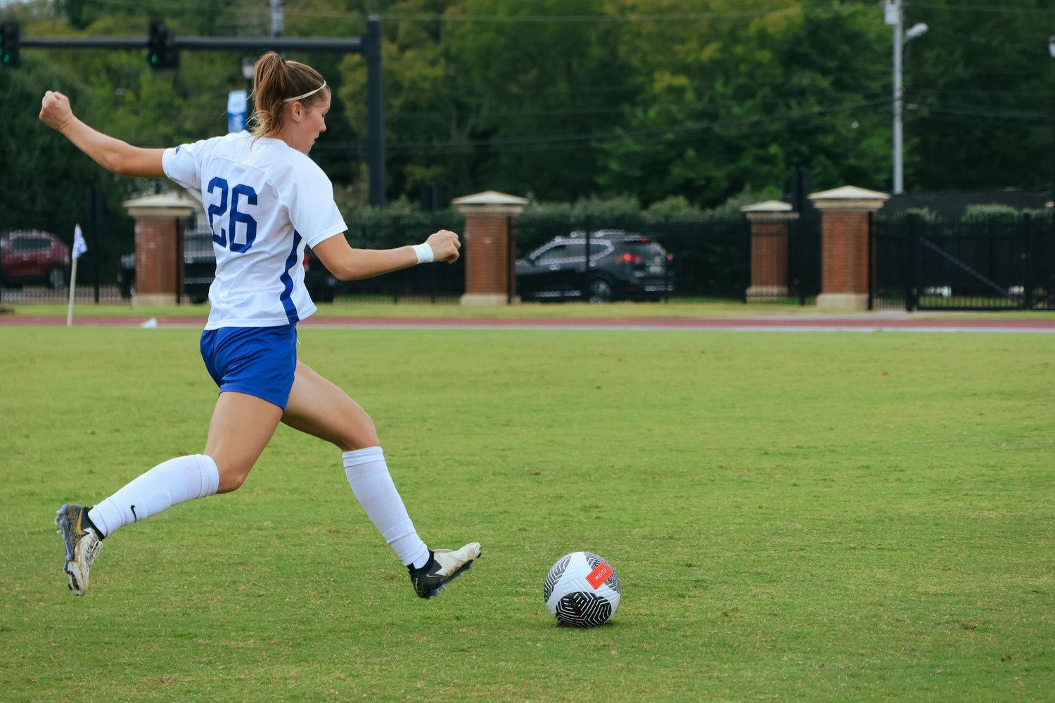Digital photograph of a soccer player (female) kicking a ball.
