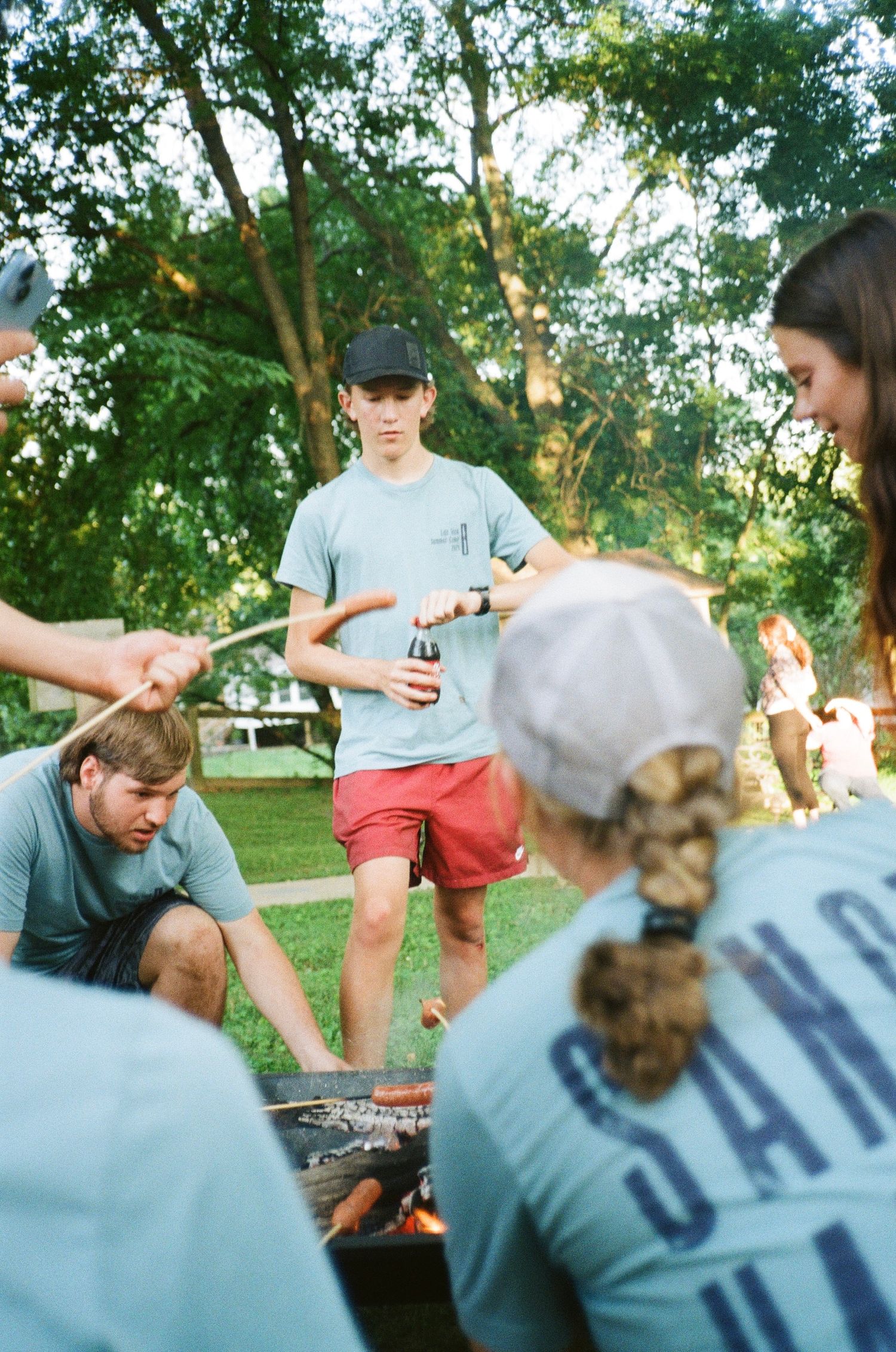 35mm photograph of a group grilling hot dogs.