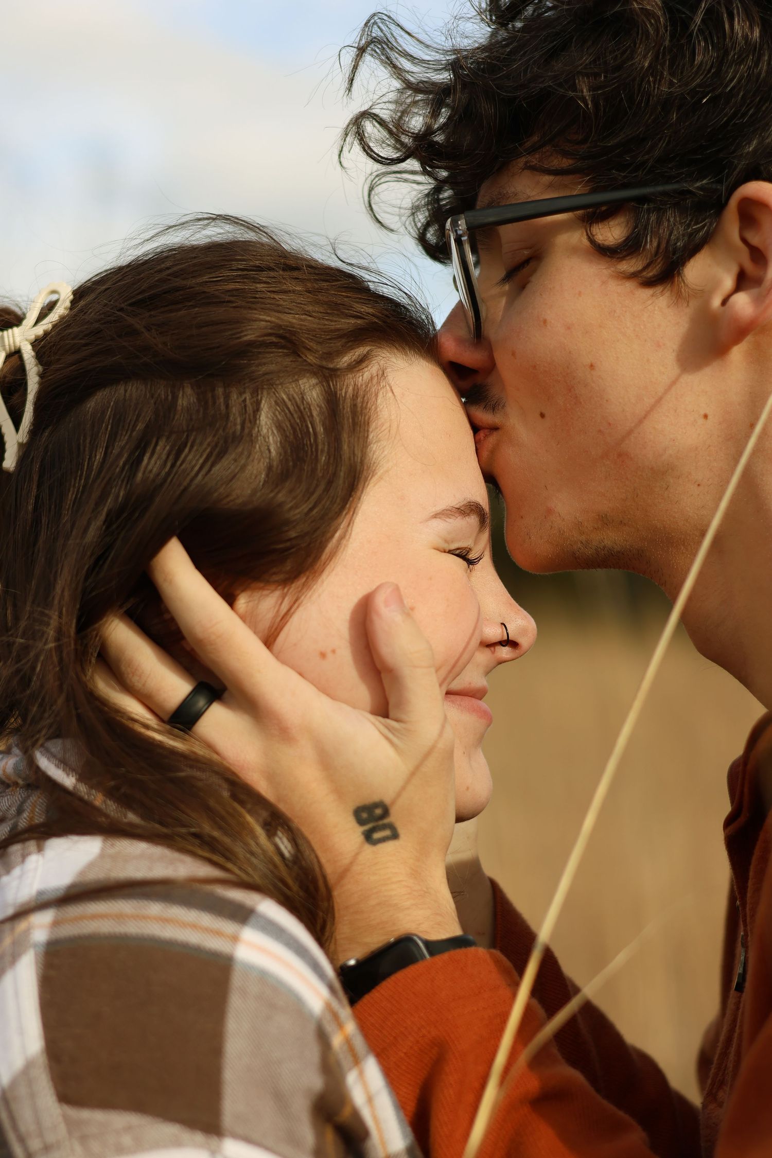 A romantic couple sharing a tender moment with their faces close together while holding a straw.