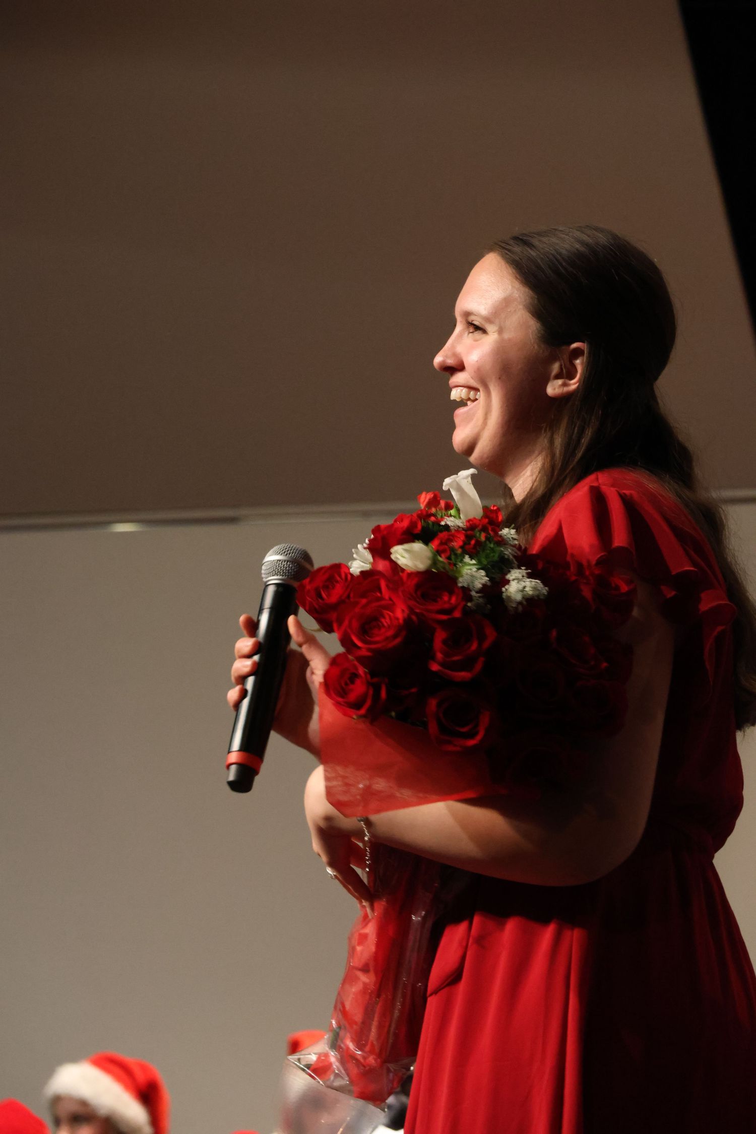 Digital photograph of a middle aged woman smiling with a bouquet.
