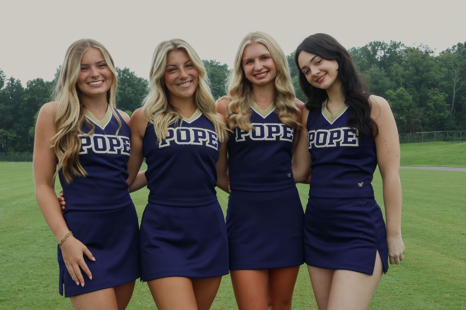 Digital photograph of 4 cheerleaders huddled together.