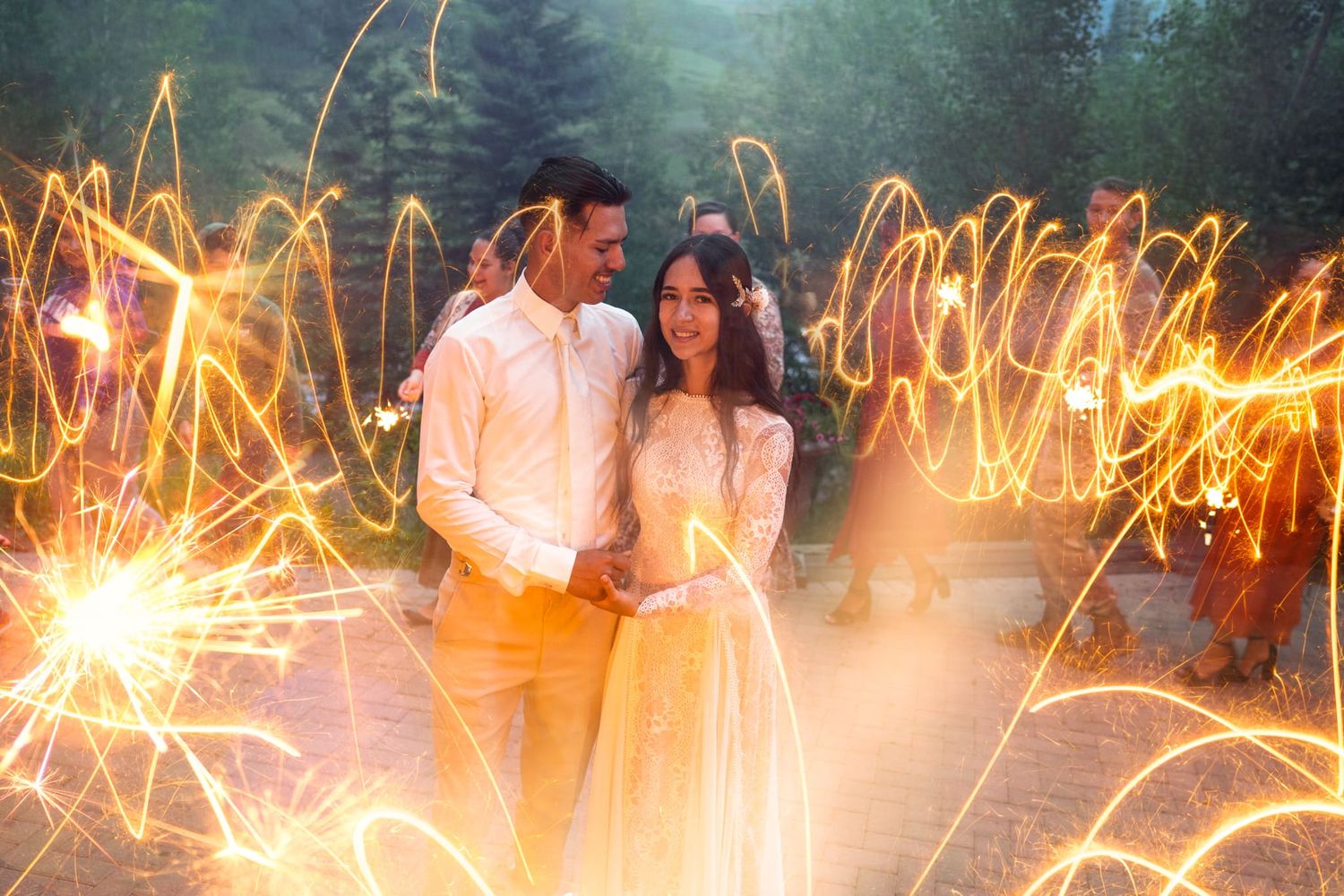 Wedding couple posing with sparklers creating light trails in the background. Mountain Garden Weddings Crested Butte Colorado