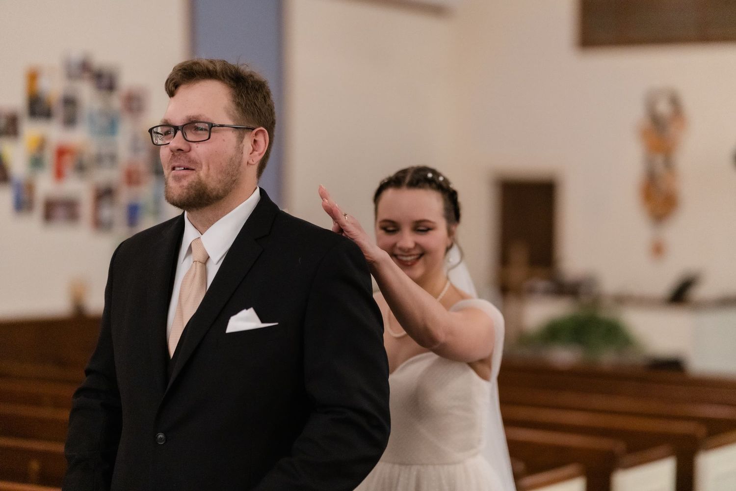 Candid moment of a bride and groom in a church setting.