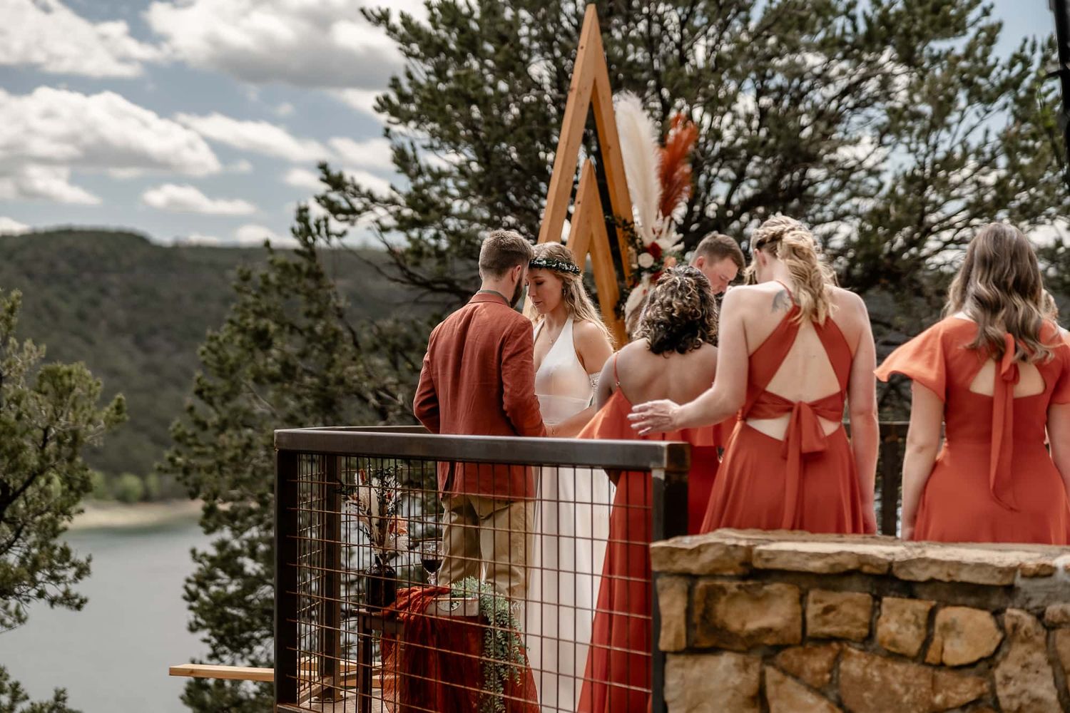 Wedding party prays over bride and groom at a mountain top wedding venue in Ridgway Colorado.