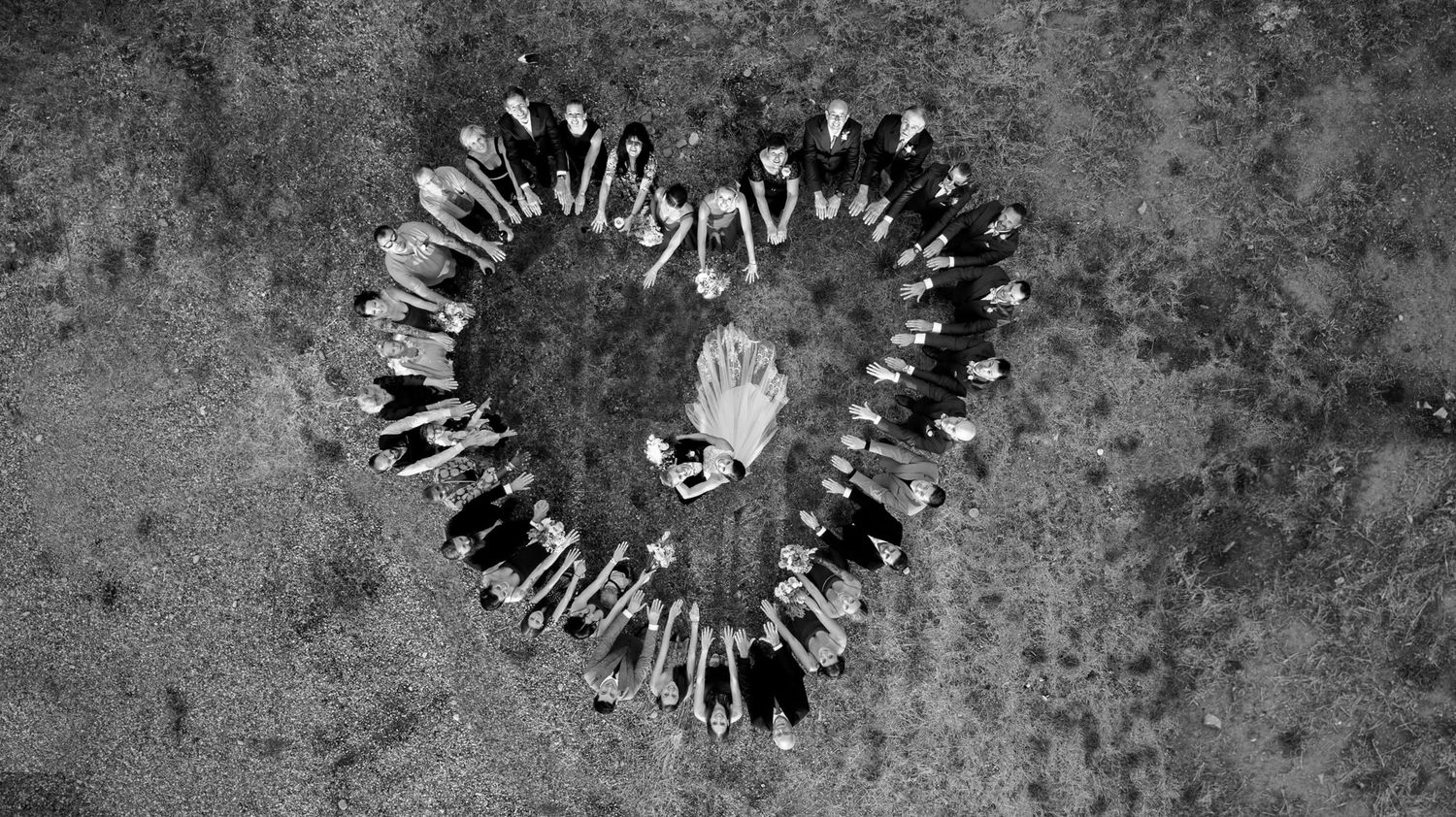 An aerial view of people forming a heart shape on a concrete surface.