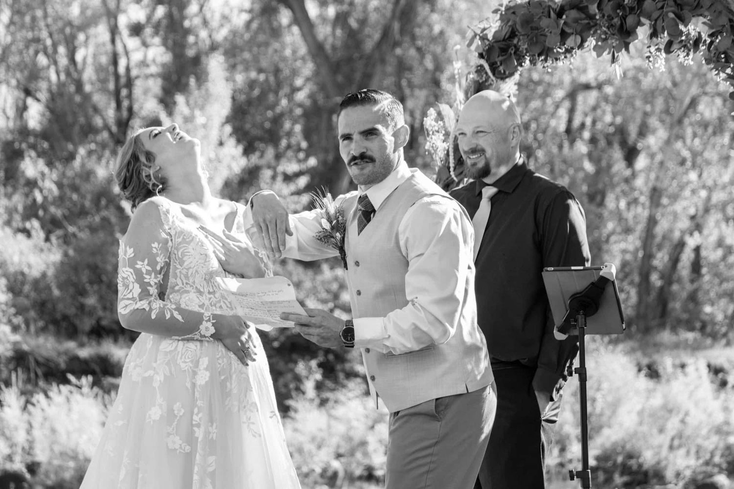 A wedding ceremony moment captured in black and white with an officiant present.