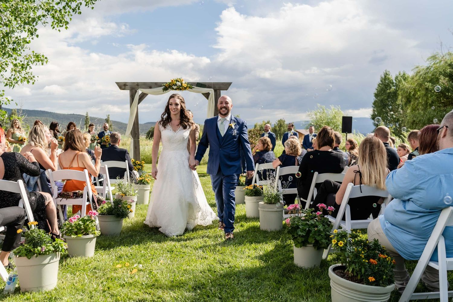 Couple walks down aisle at their wedding taken by Montrose Colorado Wedding photographers at Antler Ridge Wedding Barn Venue.