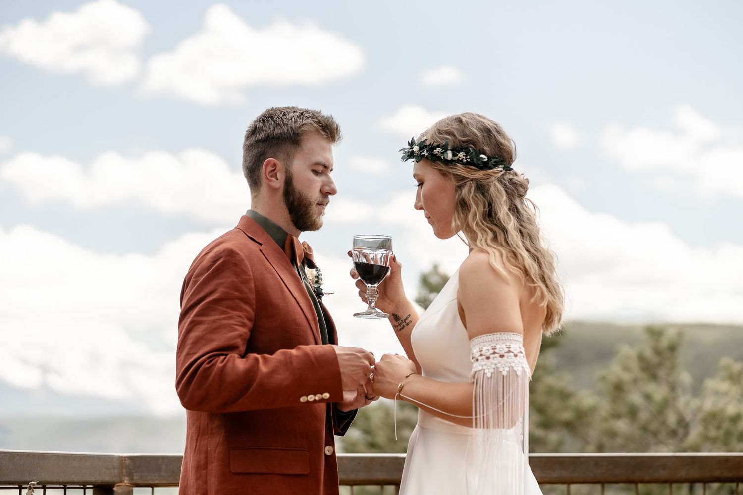 Couple takes communion at outdoor Christian Wedding with mountain views. Wedding photographer in Ridgway Colorado took this photo.