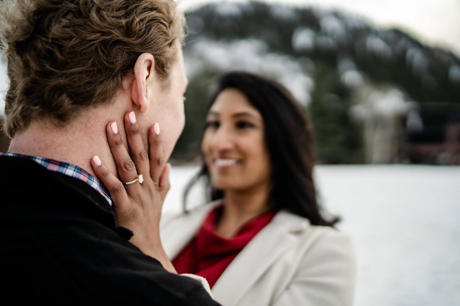 A tender moment captured between a couple during what appears to be a surprise proposal.