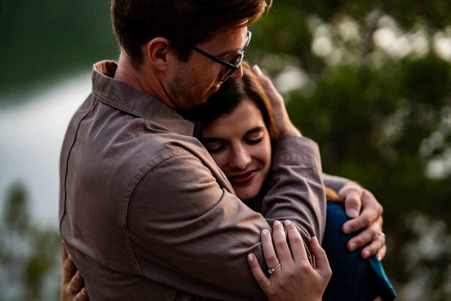 Intimate couple embracing tenderly in a romantic outdoor moment during golden hour.