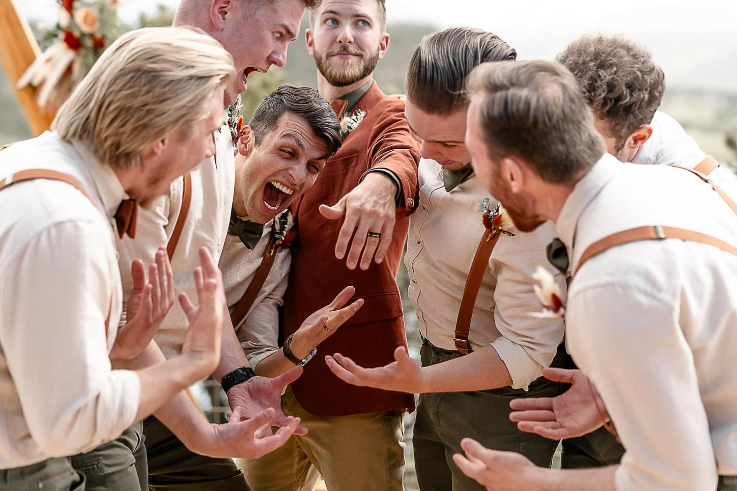 Groomsmen react with excitement and surprise during wedding celebration.