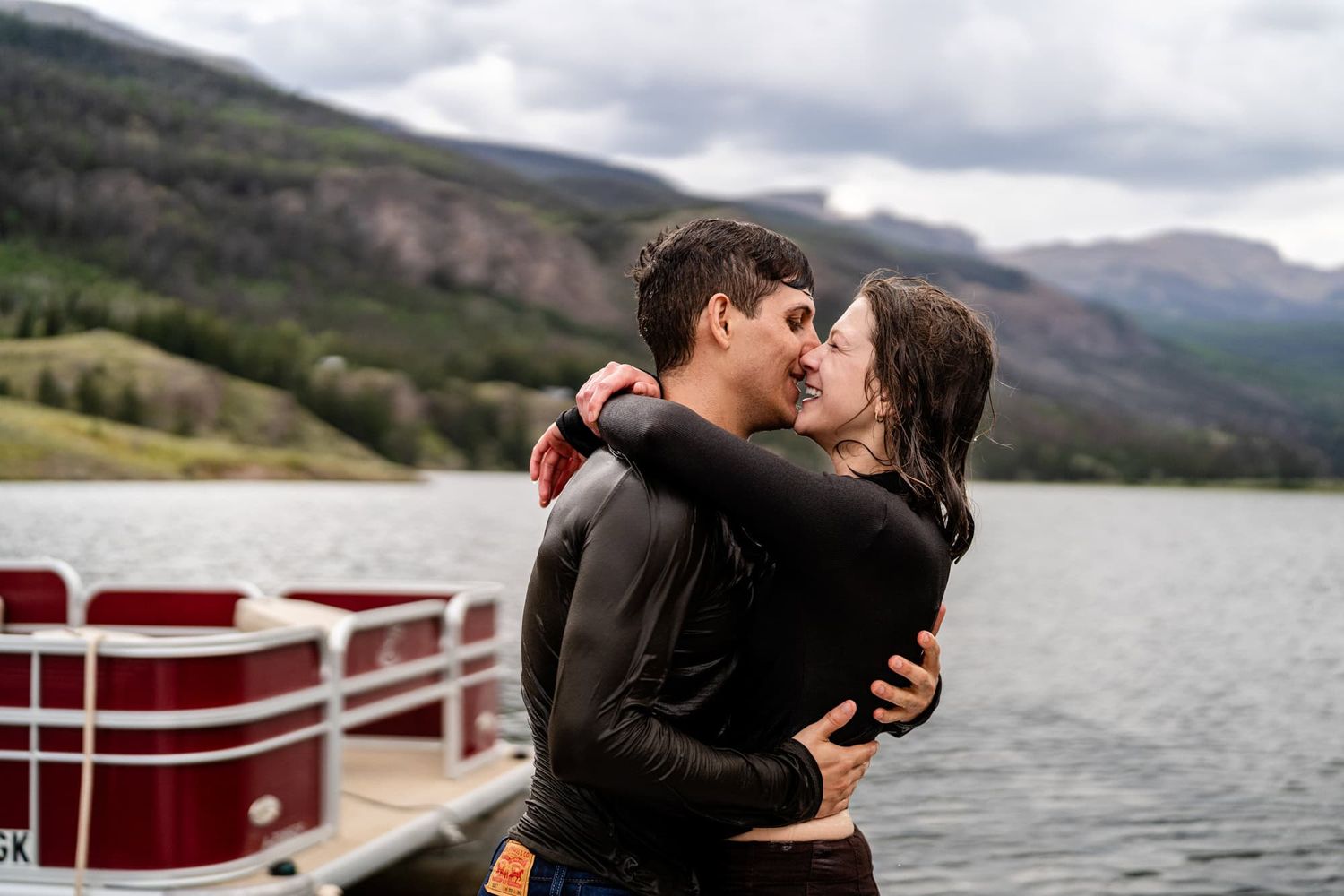 Couple shares kiss after jumping into the lake. Captured by Lake City, Colorado photographers