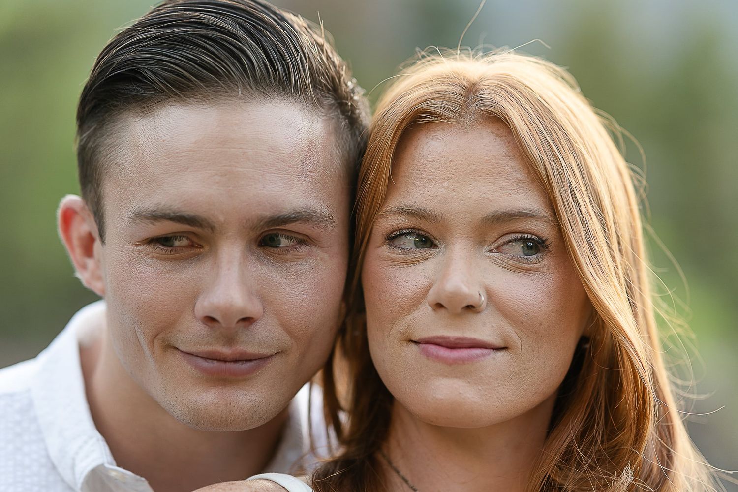 Intimate portrait of a couple smiling together outdoors.