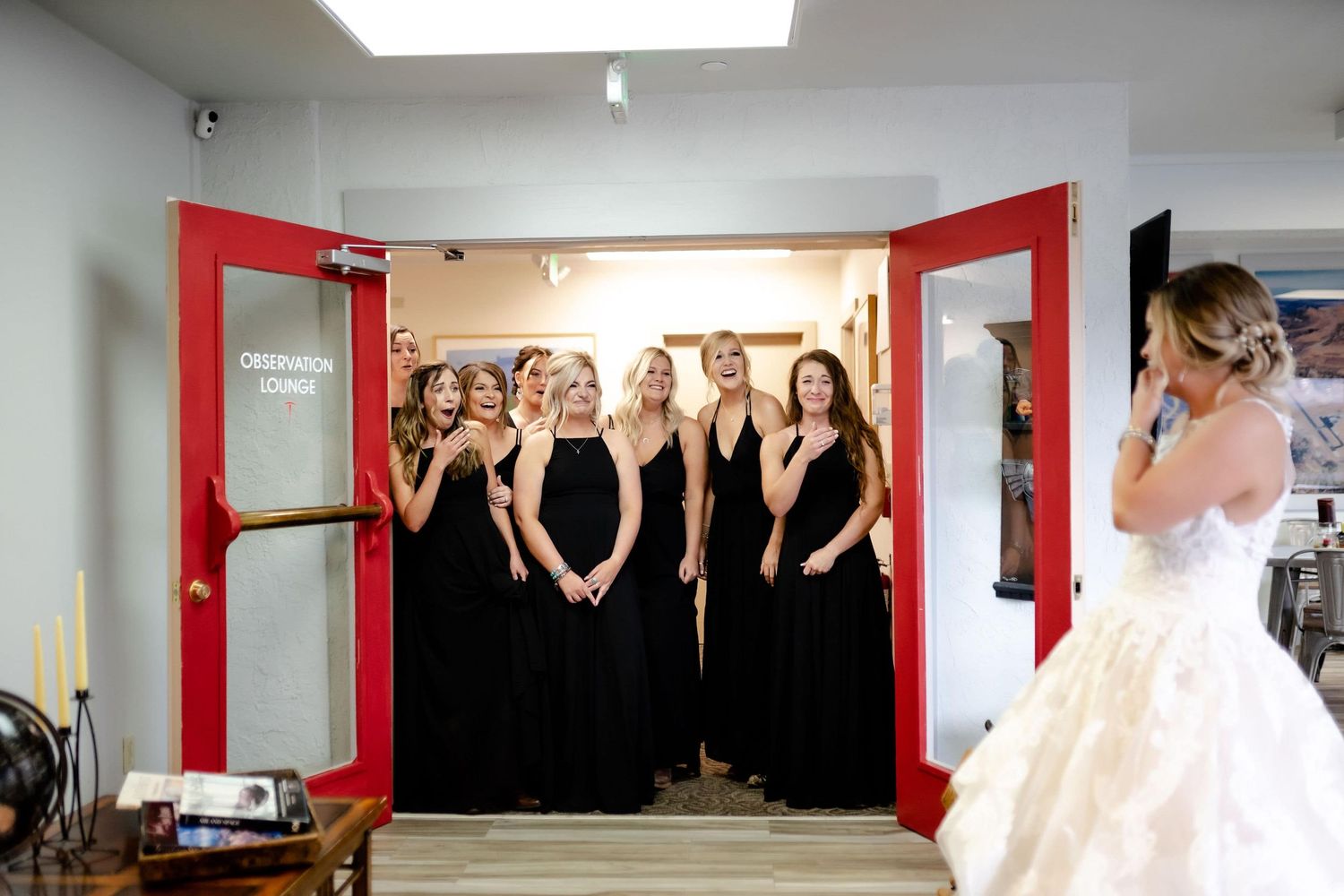 Emotional first look moment between bride and bridesmaids wearing black dresses.