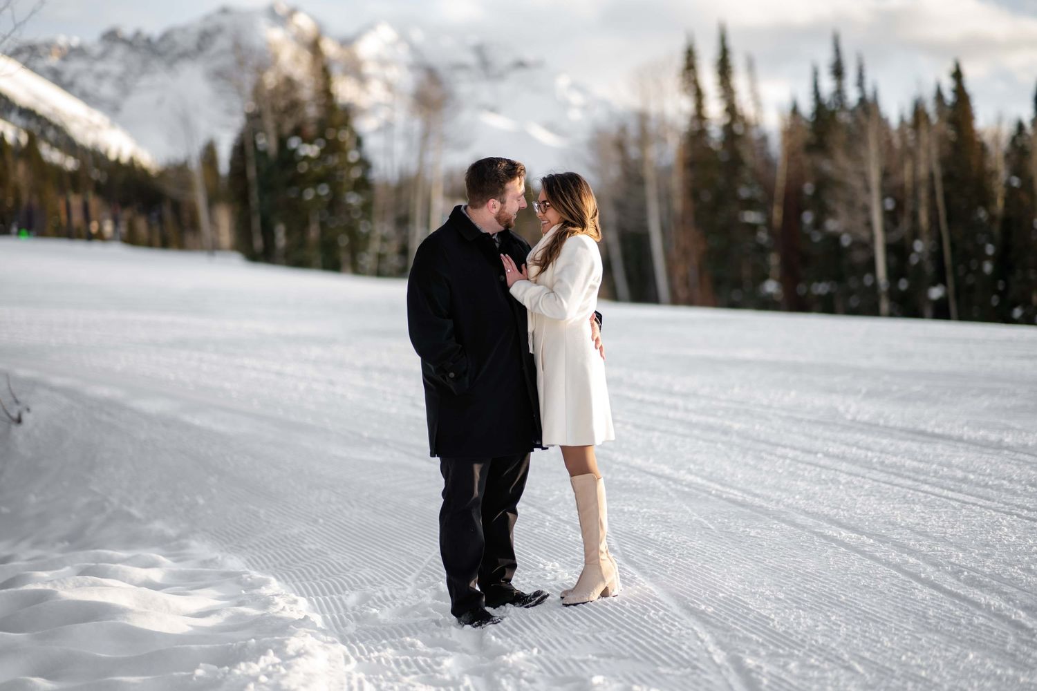 Romantic surprise proposal locations near ouray co.  A romantic winter moment in snow with snow-capped peaks in the background.