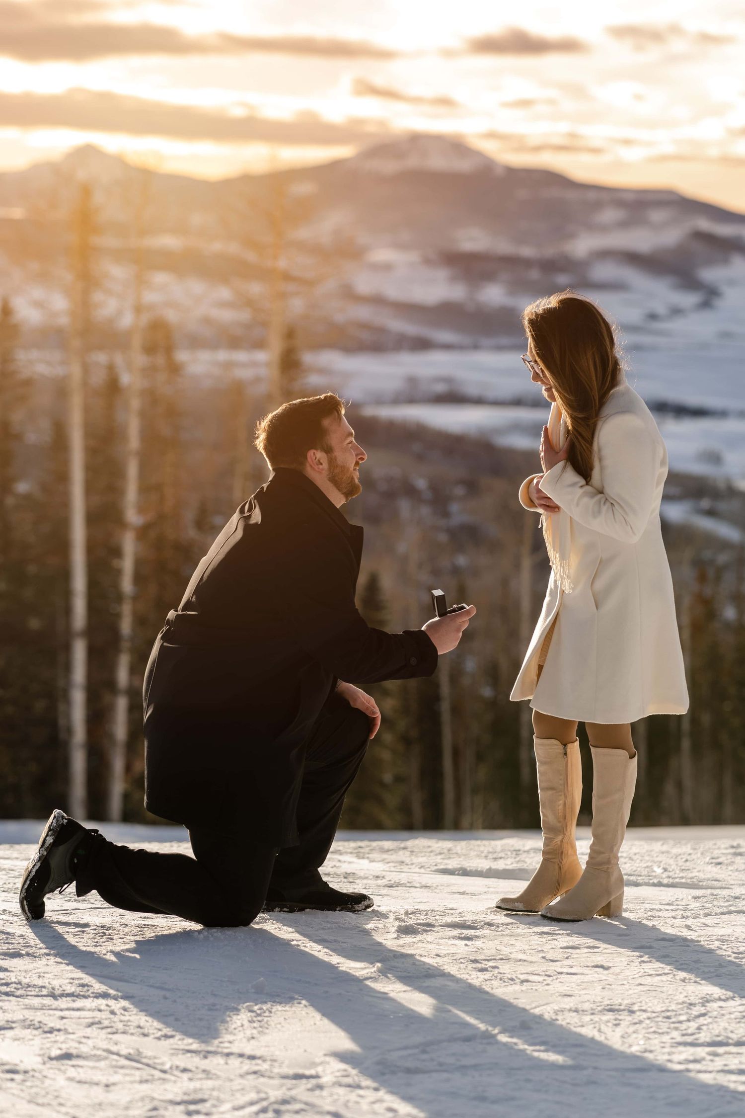 A proposal moment at sunset on a snowy mountain peak. Best place to propose near Telluride is San Sophia Overlook.