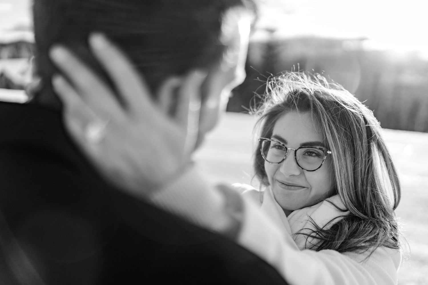 Black and white portrait capturing an intimate moment with sunlight streaming through.
