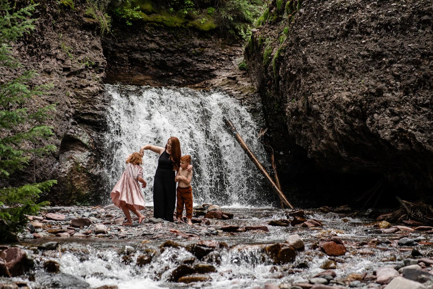 People enjoying nature together at the base of a scenic forest waterfall. Located in Telluride Colorado