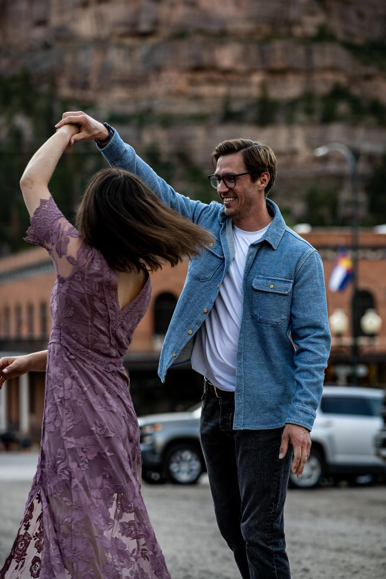 A couple dancing together against a backdrop of red rock cliffs.