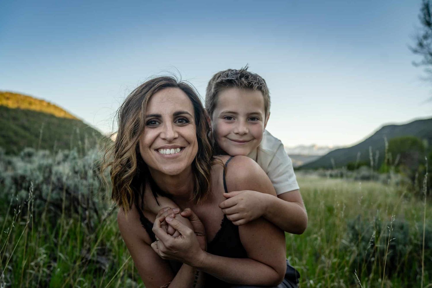 Tender embrace captured against mountain landscape at sunset.