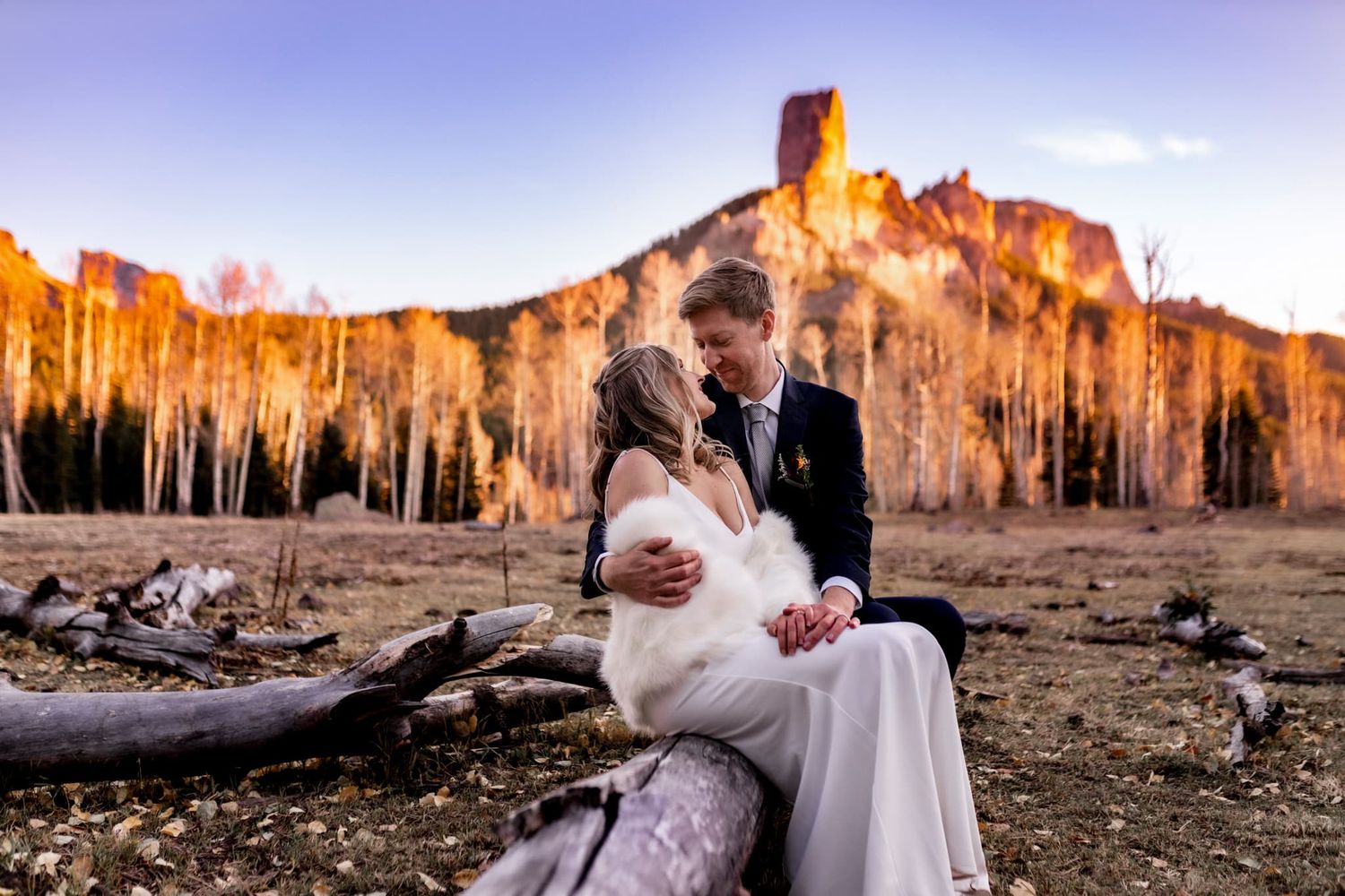 Winter wedding couple eloped with Chimney Rock behind them. Elopement photographers near Montrose Colorado shared this dreamy sunset photo.