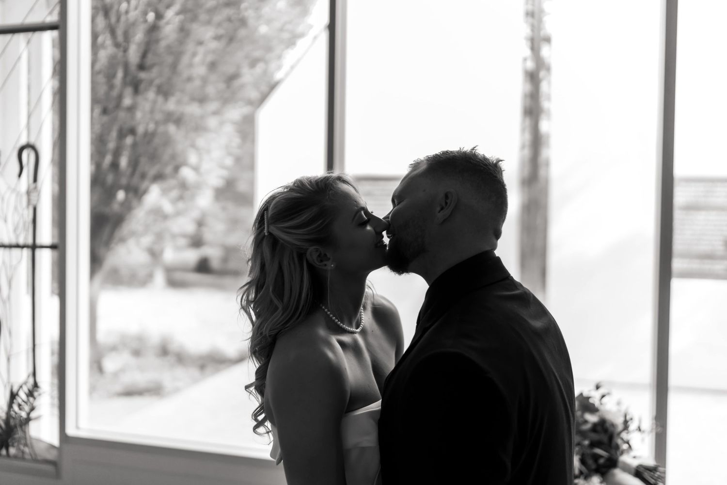 An intimate black and white portrait capturing a tender moment between newlyweds.