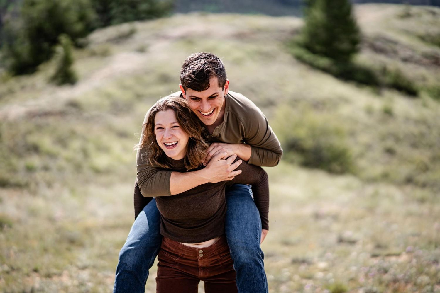 Candid moment of laughter and embraces on a scenic mountain slope.
