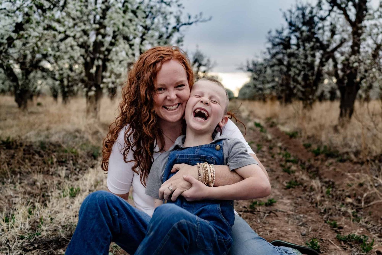 A playful outdoor portrait showing genuine laughter and joy in a natural setting.