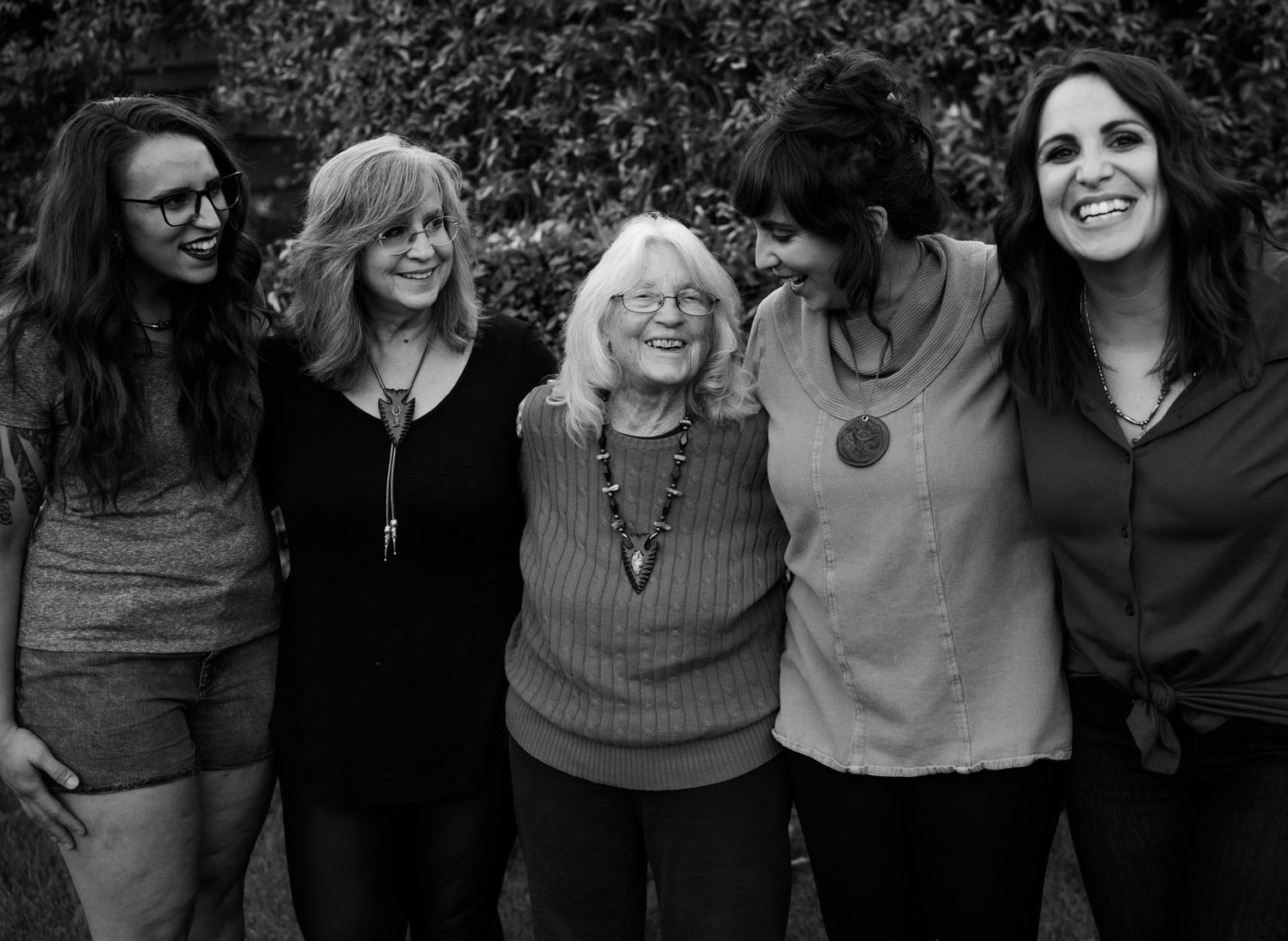 A group of women pose close together for a casual black and white portrait.