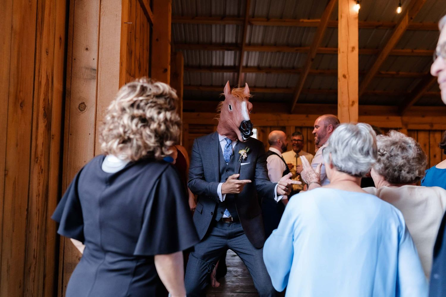 Wedding guests mingling in best rustic barn venue near montrose during reception celebration.